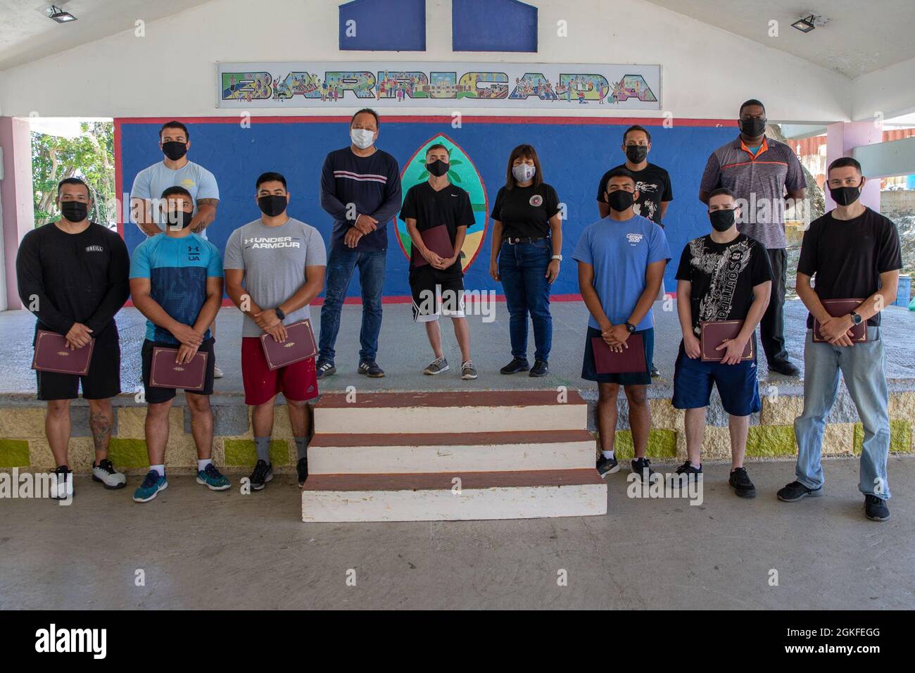 I marines statunitensi e il personale civile assegnato alla base del corpo Marino (MCB) Camp Blaz posano per una foto di gruppo con la Barrigada, il sindaco di Guam e il vice-sindaco dopo il volontariato con i dipendenti della Barrigada Mayor’s Office a Barrigada, 8 aprile 2021. Il personale dell'MCB Camp Blaz ha dipinto un parcheggio adiacente al Barrigada Community Center. Il servizio comunitario e gli eventi di volontariato consentono ai membri del servizio di costruire e promuovere relazioni positive e di restituire alla comunità. Foto Stock