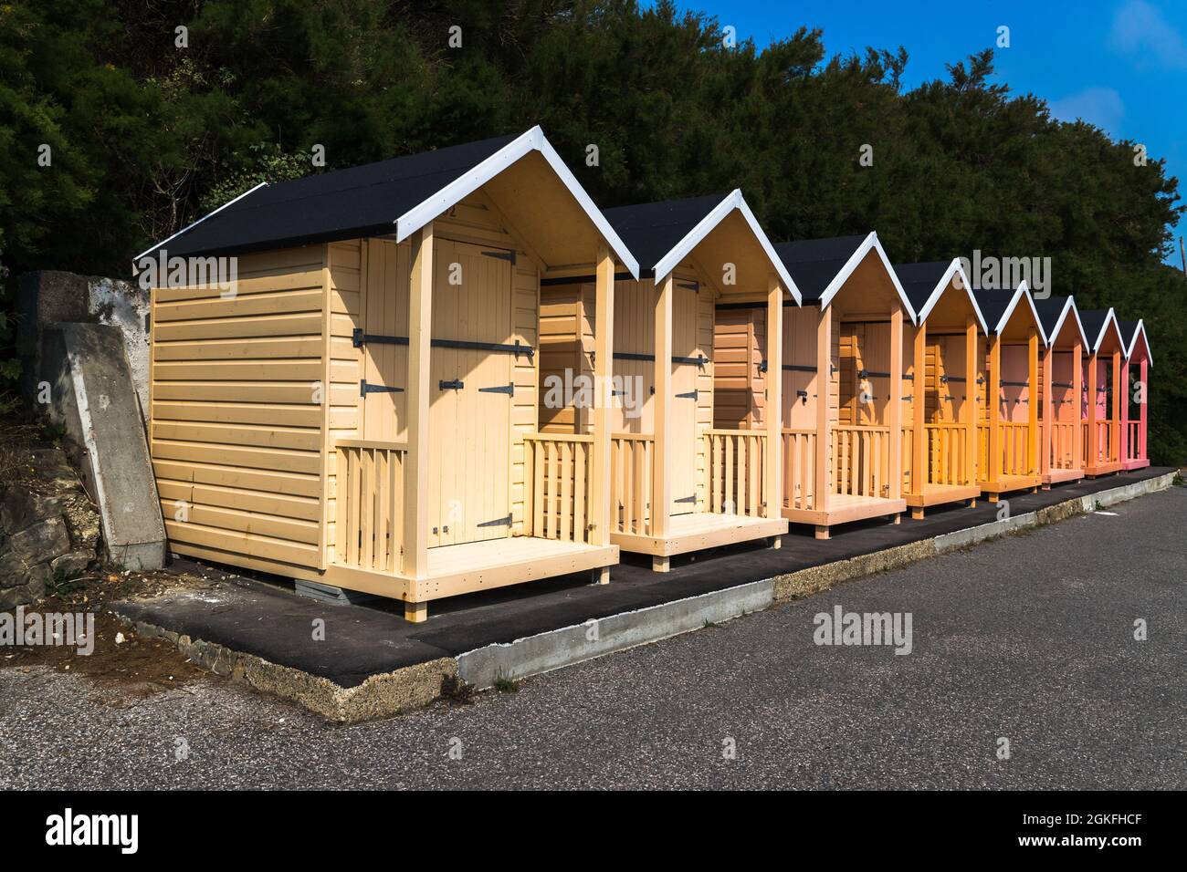 Una fila di luminose capanne sulla spiaggia si erigono fieri sul lungomare di Folkstone nel Kent, preso il 4 settembre 2021. Foto Stock