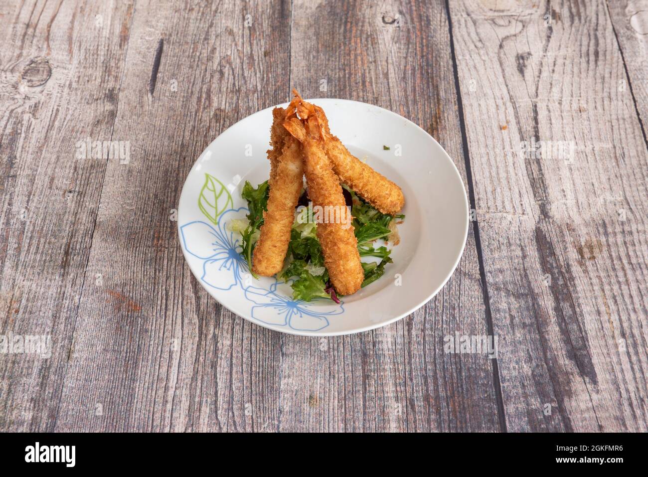 Gamberi fritti con panko sulla lattuga e un piatto da un ristorante cinese Foto Stock