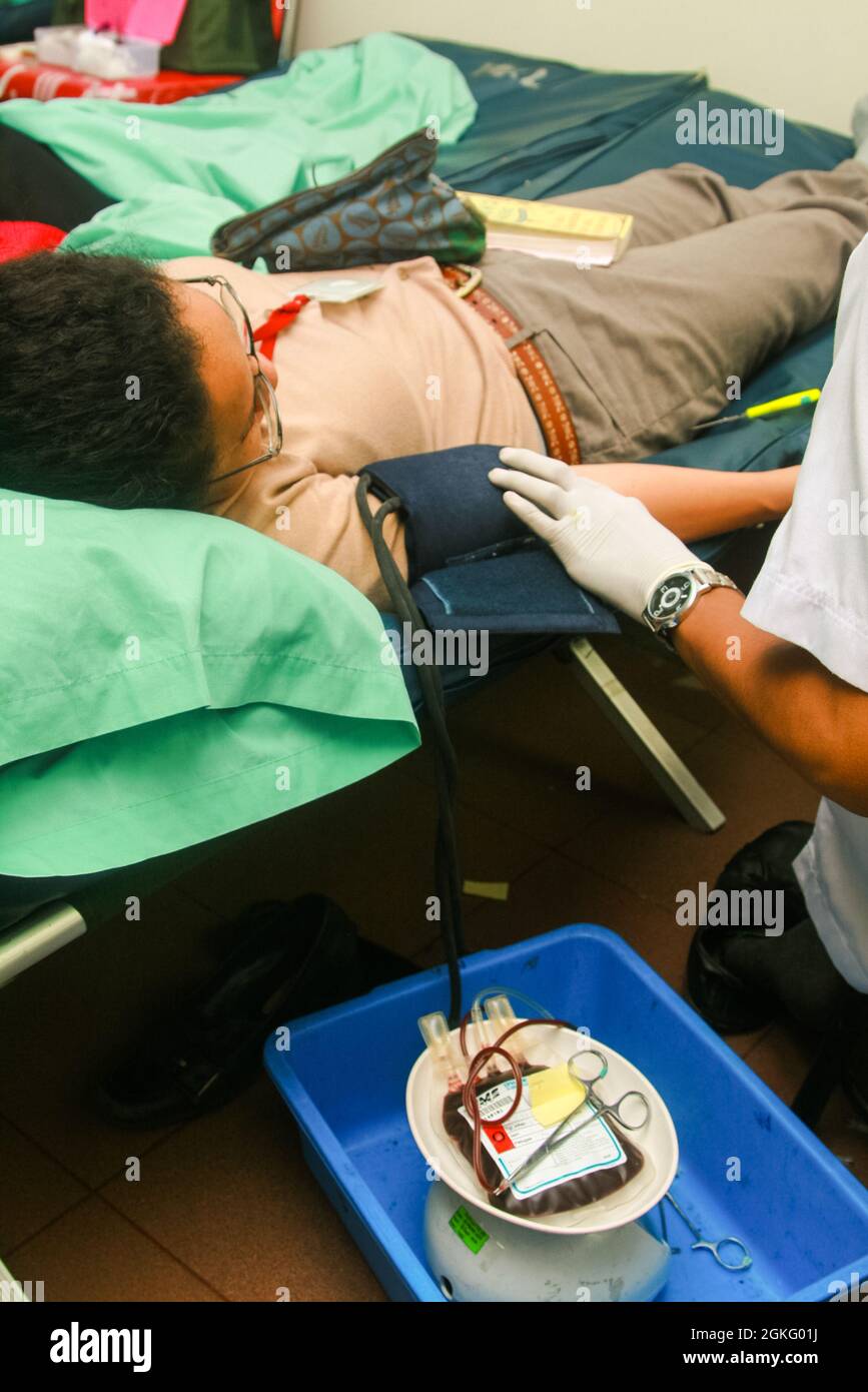 Un donatore di sangue sta facendo controllare la pressione sanguigna da un operatore sanitario durante un evento di donazione di sangue. Foto Stock