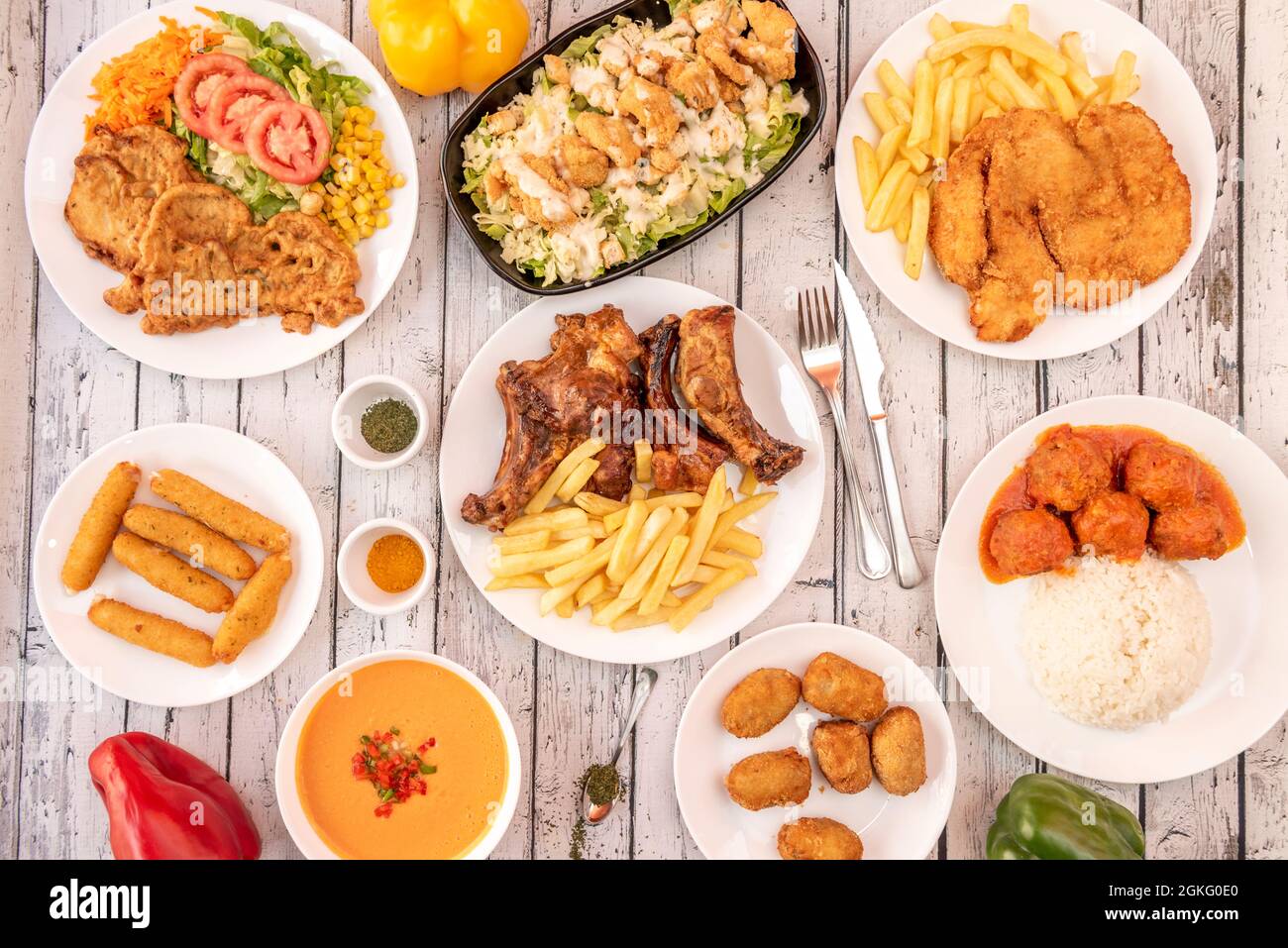 Set di piatti di popolare cucina spagnola. Crocchette di prosciutto, costolette di maiale arrosto, insalata di cesar di pollo, filetto di pollo milanese, gazpacho andaluso, polpette Foto Stock