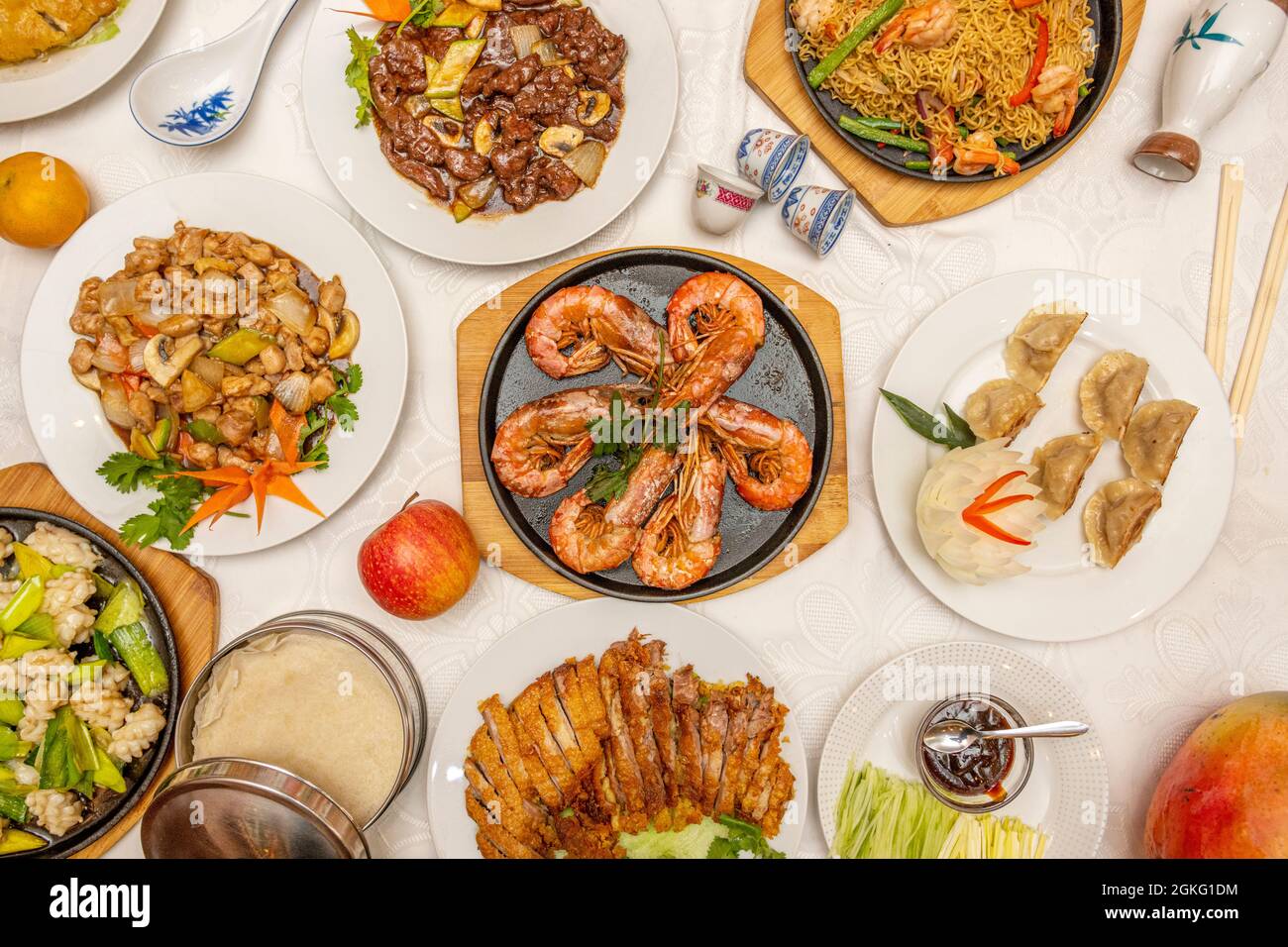 Immagine vista dall'alto dei popolari piatti cinesi del ristorante. Gamberi alla griglia, gyozas al vapore, anatra alla pechinese, pollo con mandorle, vitello con verdure, saltato Foto Stock