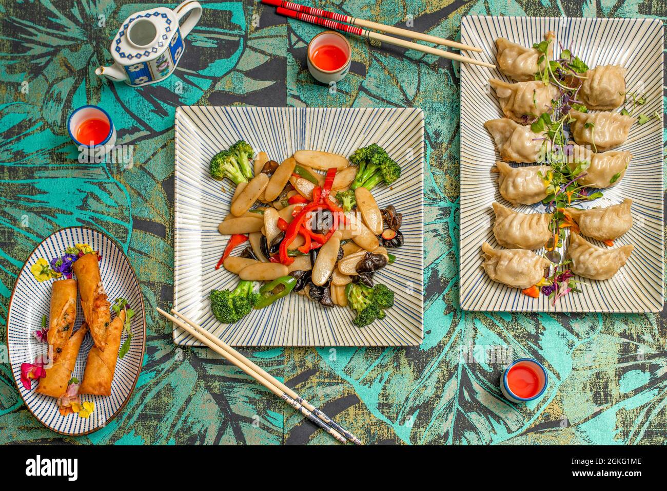 Vista dall'alto di piatti asiatici, panini di gamberi, gyozas al vapore e pasta di riso con verdure e funghi shiitake Foto Stock