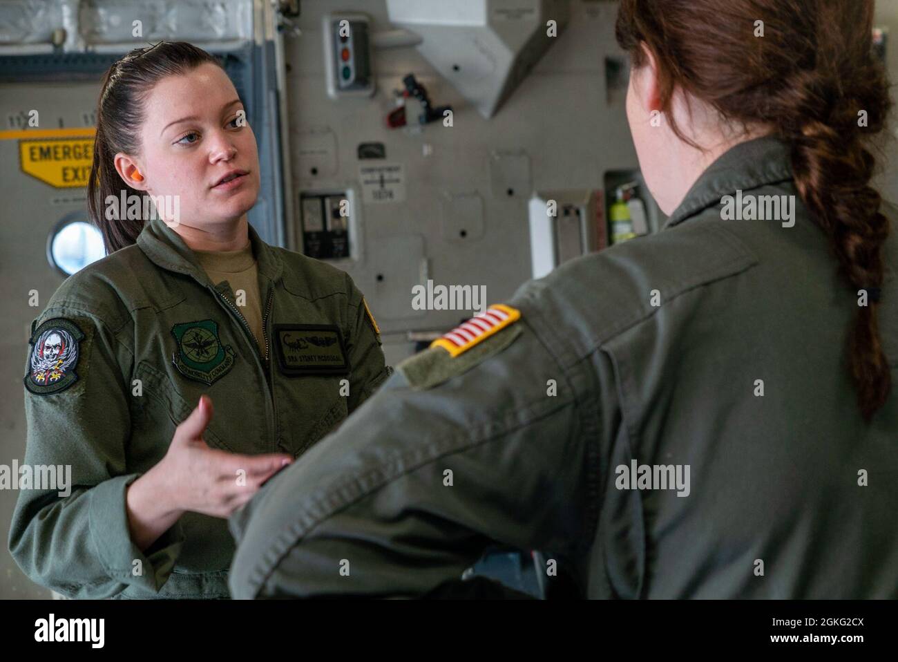 I Senior Airmen dell'Aeronautica militare degli Stati Uniti Sydney Mcdugal e Grace Tinkey, loadmasters assegnati al 15° Airlift Squadron presso la Joint base di Charleston, parlano prima di un salto di linea statico a Fort Bragg, North Carolina, 13 aprile 2021. In occasione della Giornata Nazionale delle Donne, il volo consisteva di un equipaggio di volo femminile e di paracadutisti aerei. Foto Stock