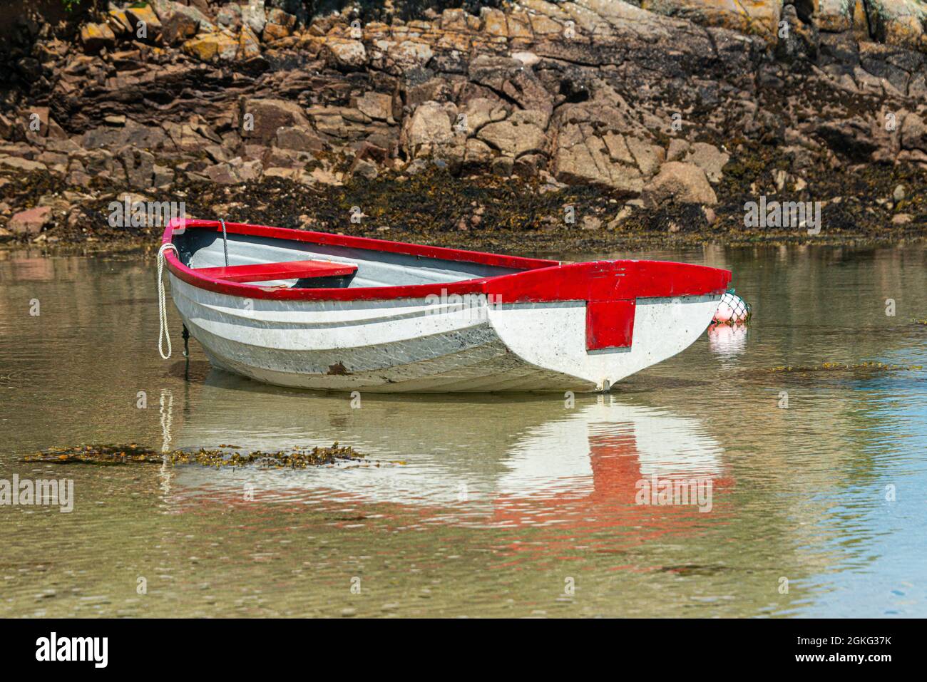 Una barca di legno rossa e bianca in Kitchen Porth, Bryher, Isole di Scilly Foto Stock