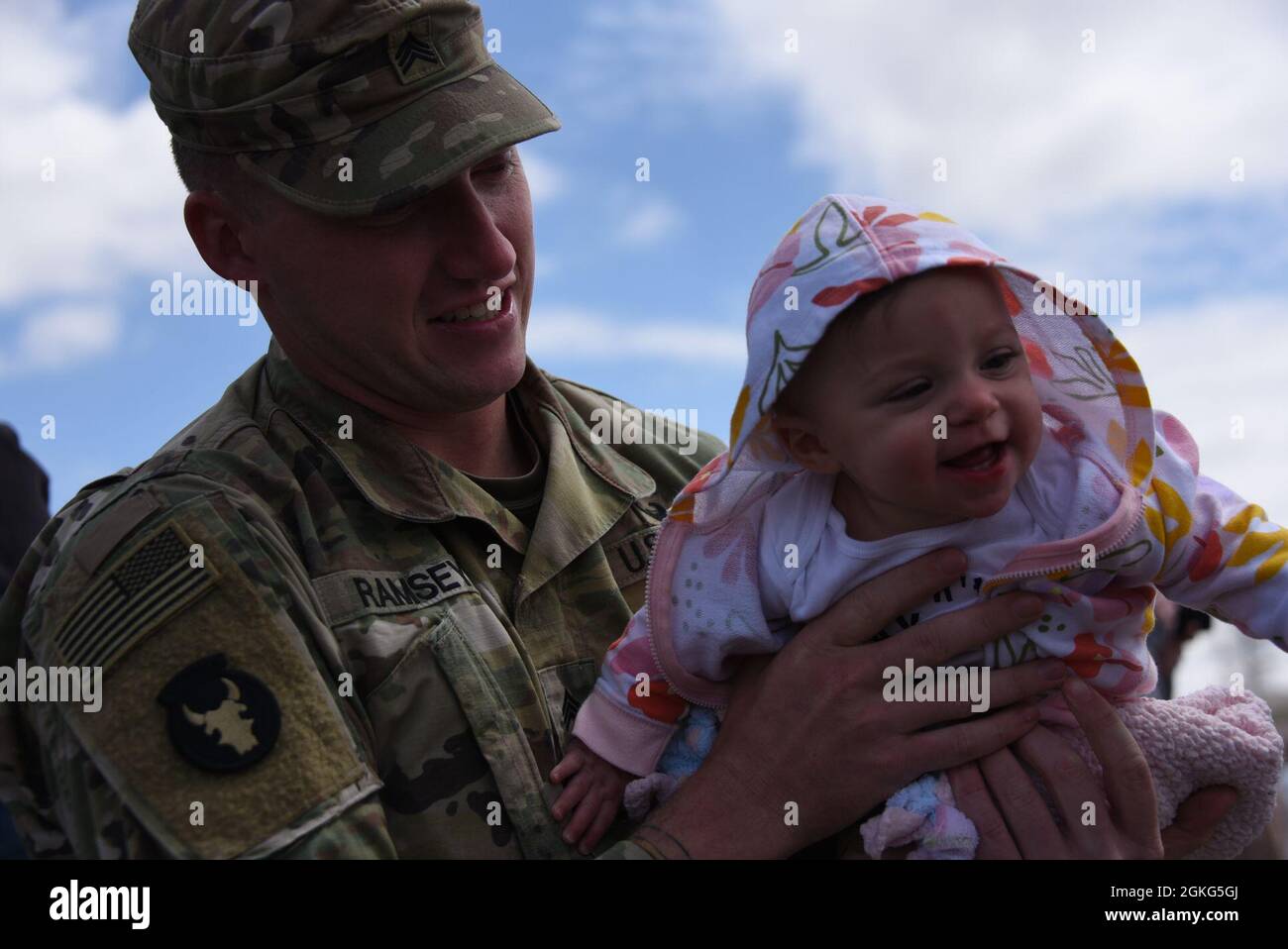 A Soldier from the le Mars, Iowa based C-Troop 1-113esimo Cavalleria della Guardia Nazionale Iowa tiene il suo bambino al suo ritorno in Iowa il 14 aprile 2021 dopo un dispiegamento di 10 mesi al Corno d'Africa. La contingenza di quasi 90 soldati ritornò al le Mars, Iowa Armory. Foto della Guardia Nazionale degli Stati Uniti Senior Master Sgt. Vincent De Groot Foto Stock