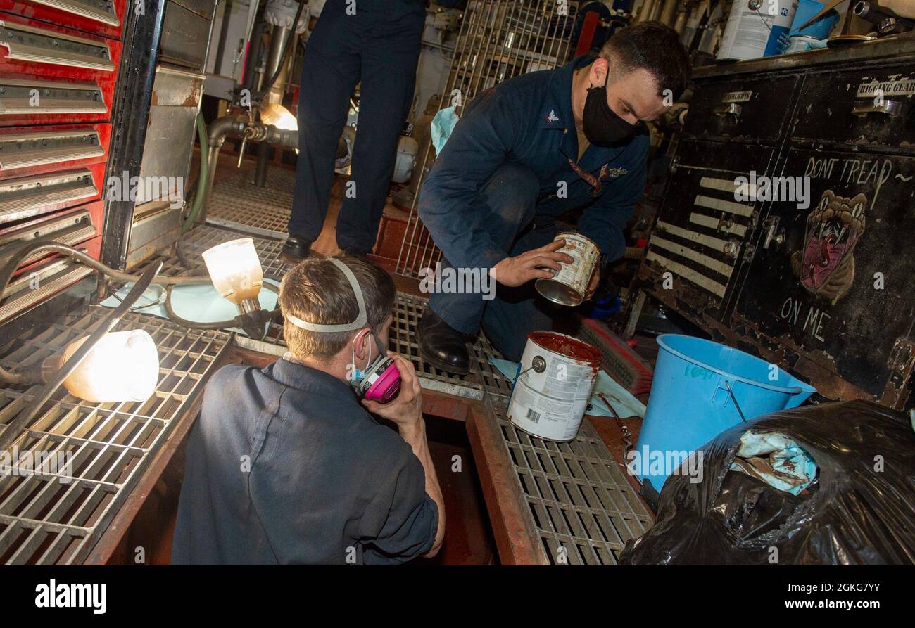 210414-N-EH998-1082 PORTSMOUTH, Va. (14 aprile 2021) il Mate Fireman di Machinist Chris Harearn, a sinistra, da Columbia, Illinois, e il Mate di Machinist di terza classe Matthew Kahler, da Toledo, Ohio, passa la vernice a bordo della portaerei USS George H. W. Bush (CVN 77). GHWB è attualmente a Norfolk Naval Shipyard per il suo docking pianificato Incremental Availability. Foto Stock
