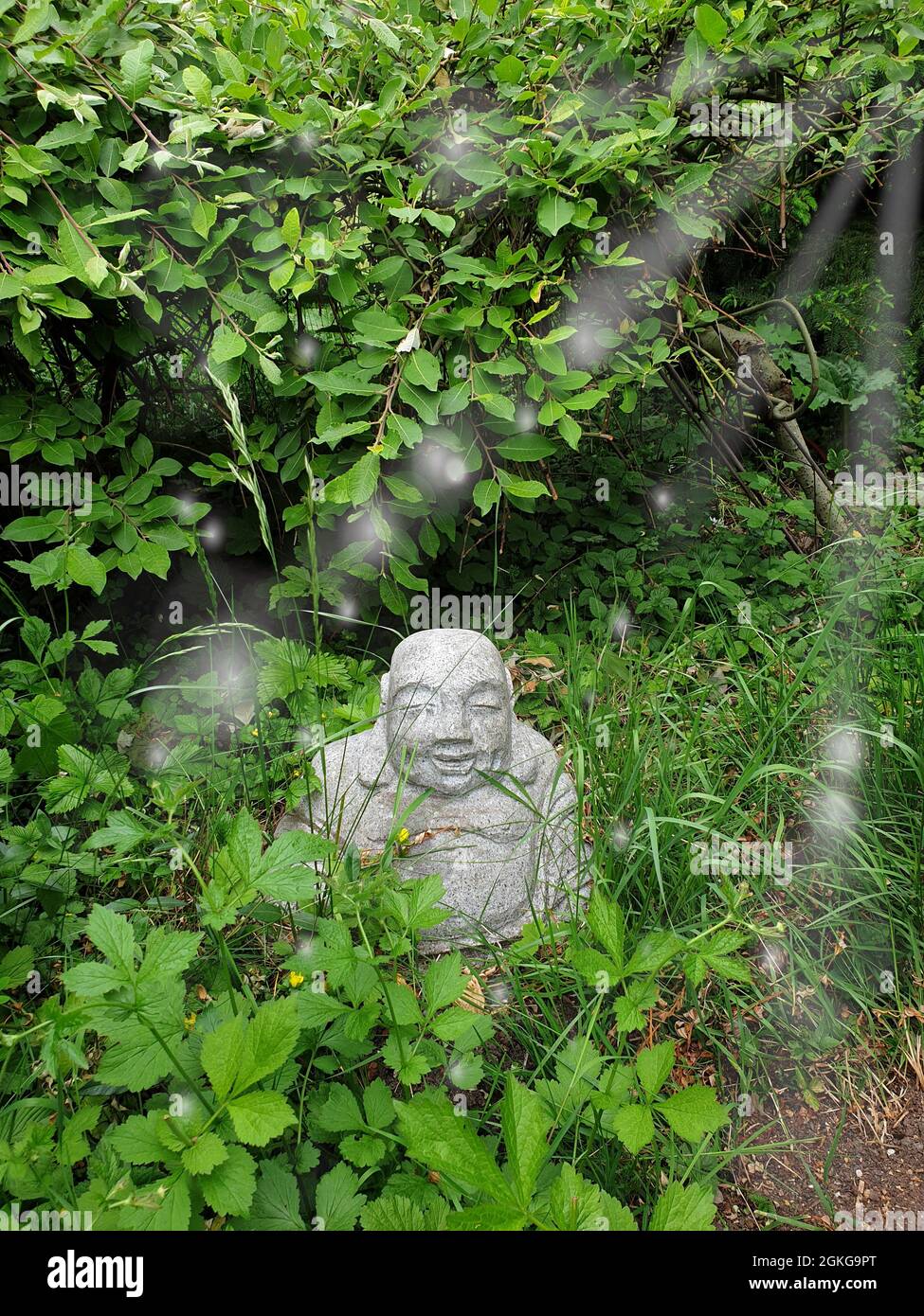 Piccolo Buddha in giardino Foto Stock