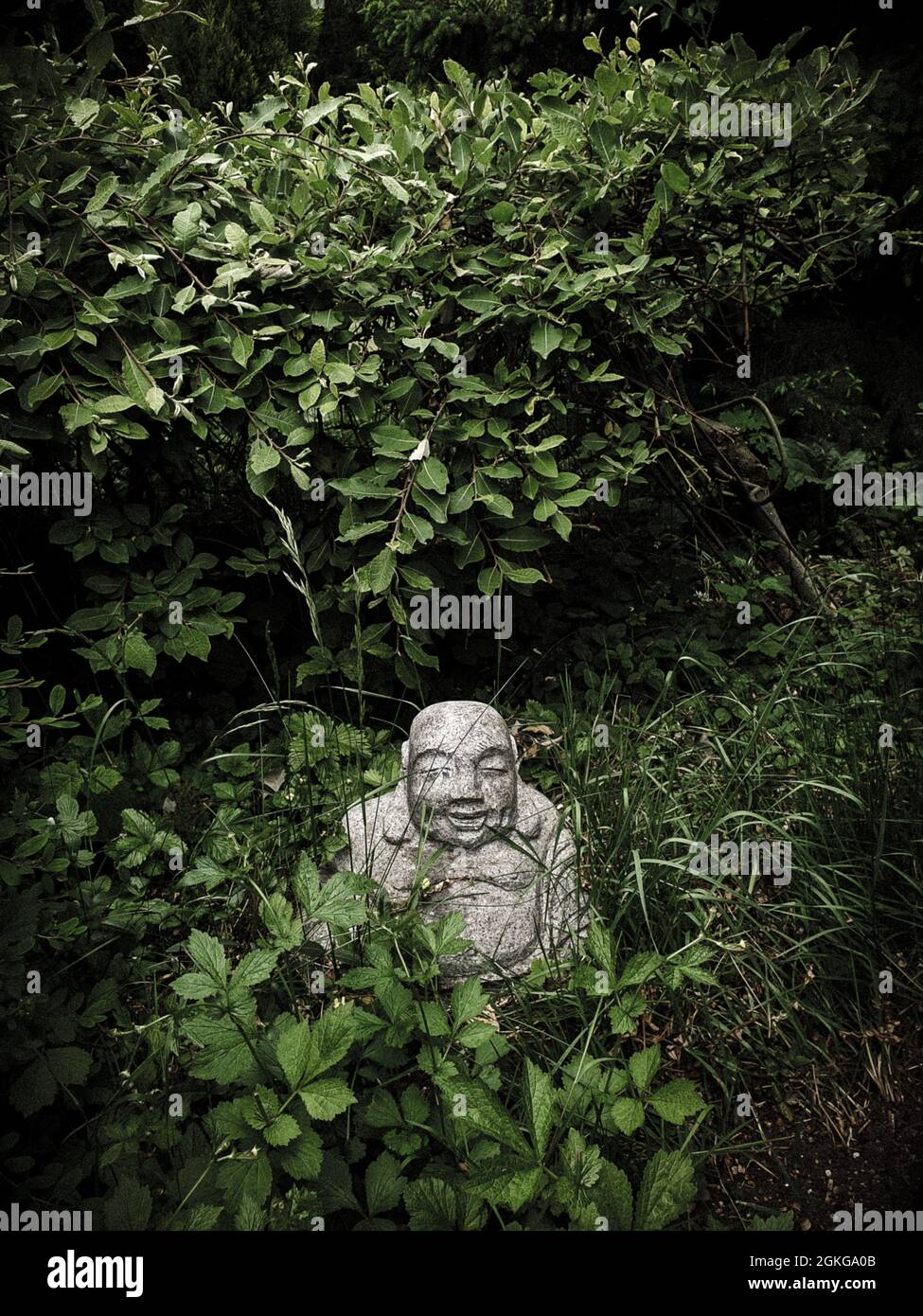 Piccolo Buddha in giardino Foto Stock