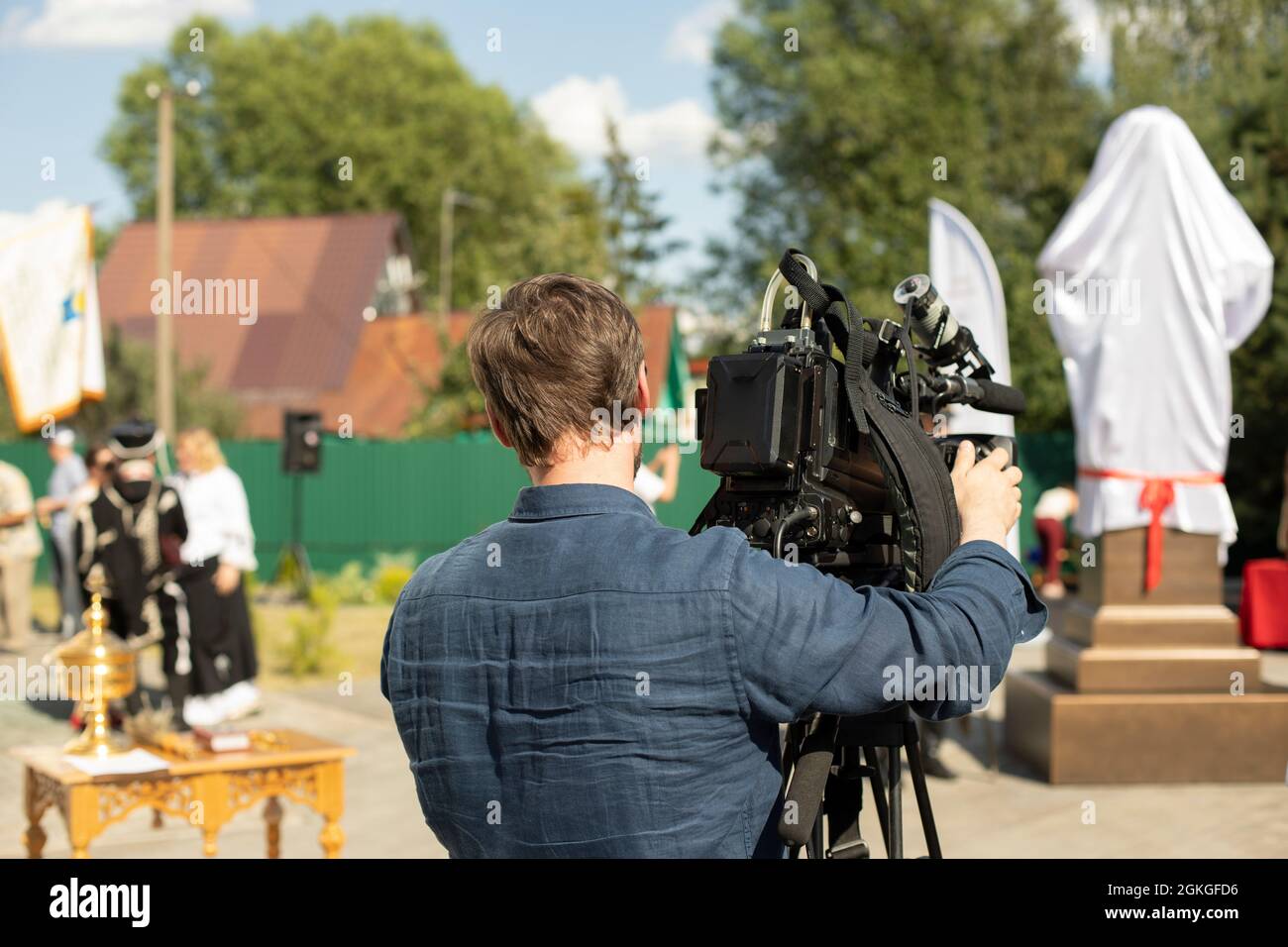 L'operatore video sta riprendendo. L'operatore si trova vicino alla videocamera. Il lavoro del canale televisivo. L'uomo scatta con la fotocamera. Foto Stock