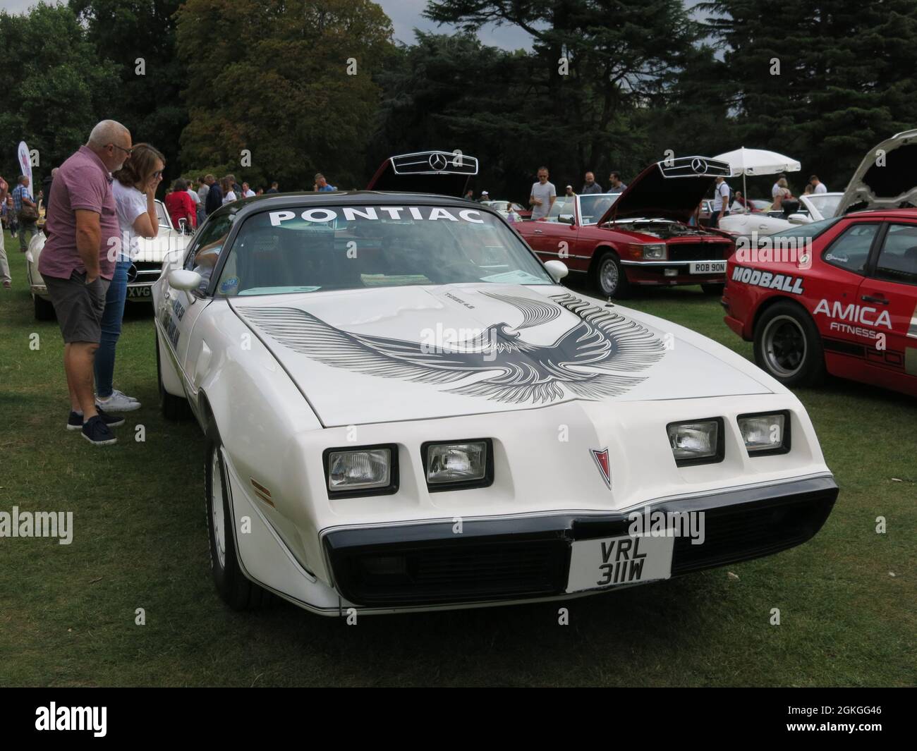 Un Pontiac Firebird bianco ammirato da una coppia mentre in mostra al classico spettacolo di auto durante il fine settimana del patrimonio a Delatre Abbey Foto Stock