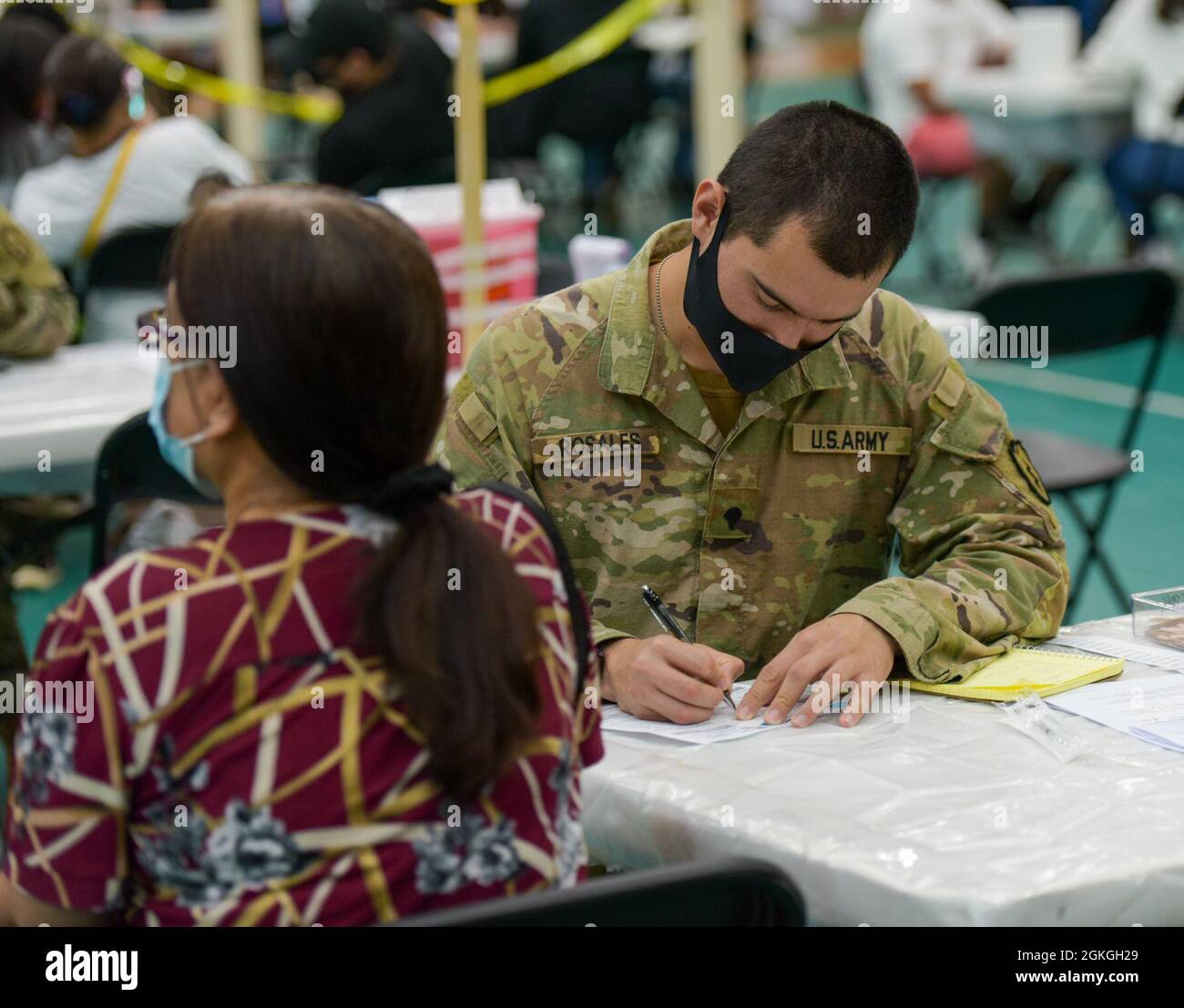 MANGILAO, Guam (16 aprile 2021) – SPC. Julio Rosales, uno specialista di mediche da combattimento assegnato alla 25a Divisione di fanteria, controlla le informazioni sui pazienti prima di somministrare un vaccino COVID-19 a supporto del team di vaccinazione COVID-19 del Dipartimento di Sanità pubblica e servizi sociali (DPHSS) presso una clinica di vaccinazione tenuta presso la Casa campo dell'Università di Guam Calvo. Il comando IndoPacifico degli Stati Uniti, attraverso l'Esercito Pacifico degli Stati Uniti, continua a fornire supporto flessibile al Dipartimento della Difesa dell'Agenzia federale per la gestione delle emergenze come parte della risposta dell'intero governo al COVID-19. Foto Stock