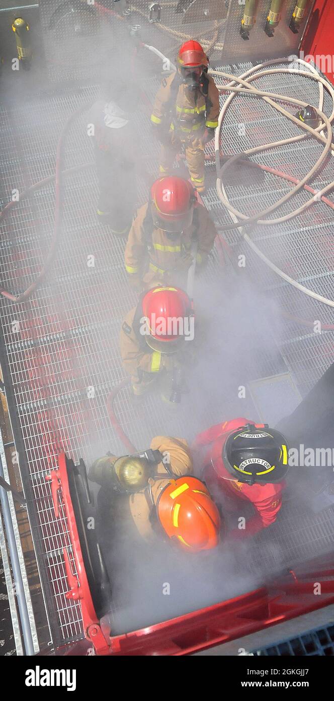 Una squadra di soldati entra nella camera di livello superiore dell'addestratore antincendio per individuare ed estinguere le fiamme durante la formazione 88K Waterercraft Operator Course aprile 16 alla base comune di Langley-Eustis. Foto Stock