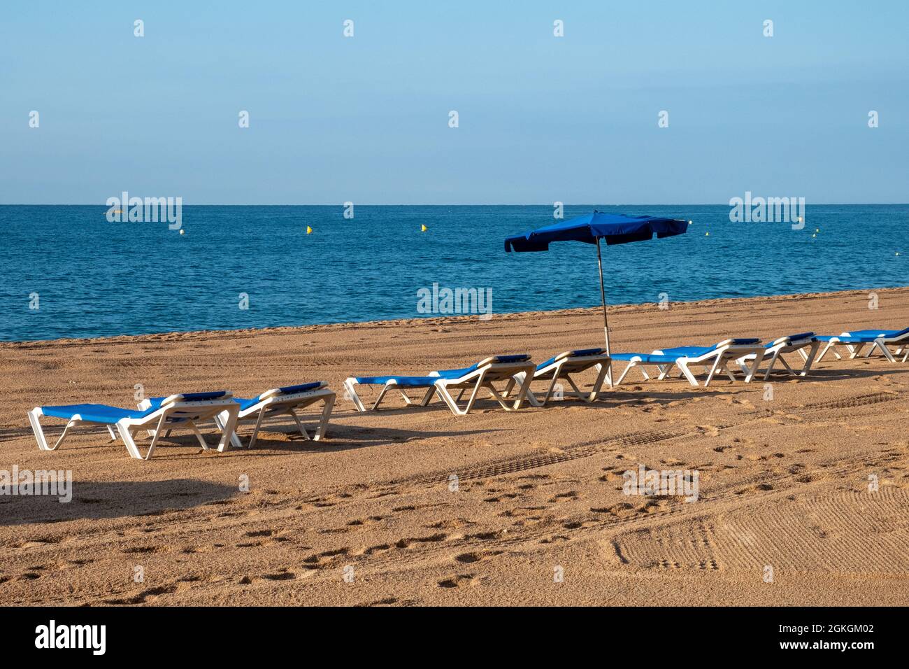 Sedie a sdraio vuote sulla spiaggia in Spagna Foto Stock