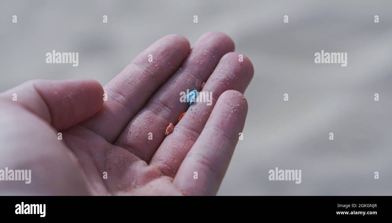 Vista laterale di un supporto manuale in plastica con spazio di copia. Materiali non riciclabili. Focalizzazione selettiva delle microplastiche. Riscaldamento globale e clima chan Foto Stock