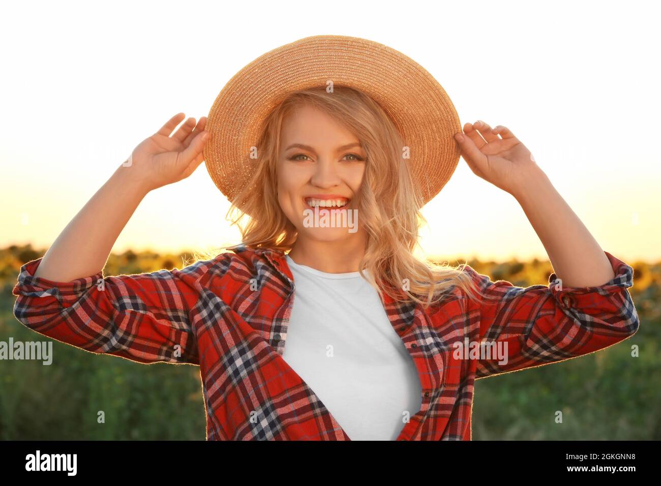 Giovane donna che posa con cappello di vimini all'aperto Foto stock - Alamy