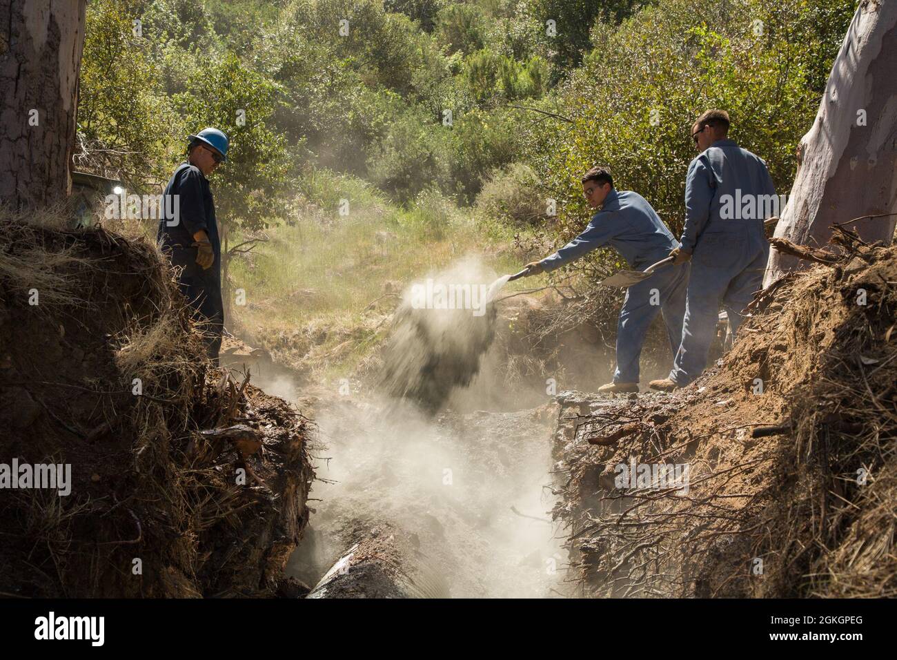 Marines USA con Marine Wing Support Squadron (MWSS) 373, coprire un culvert con portland e sporcizia durante le riparazioni stradali a Santa Catalina Island, California, 17 aprile 2021. La prontezza operativa e la natura ad adattamento rapido consentono alla MWSS-373 di lavorare in modo efficiente su strade e strade, manovrando al contempo il terreno montuoso mostrando come i Marines superino gli ostacoli e si adattino all'ambiente circostante. Foto Stock