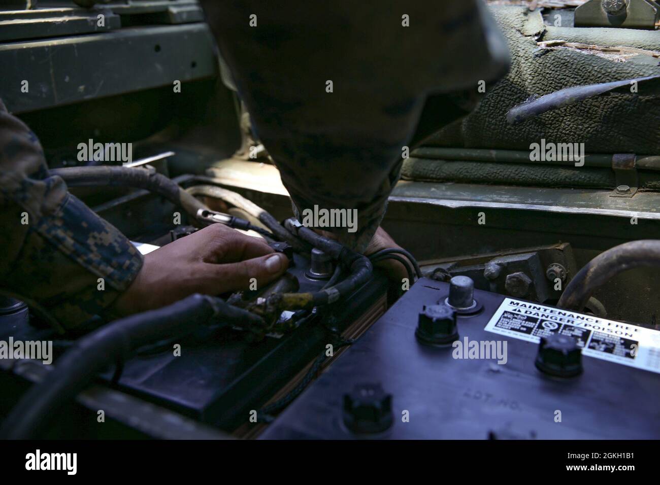 US Marine Corps Lance CPL. Dennis Borel, un tecnico di manutenzione automobilistica con Ordnance Maintenance Company (OMC), 3d Maintenance Battalion, 3d Marine Logistics Group (MLG), sostituisce la batteria su un veicolo gommato multiuso ad alta mobilità nella Landing zone Kiwi, Okinawa, Giappone, 20 aprile 2021. OMC Marines esegue regolarmente interventi di manutenzione su campi e terreni per mantenere l'efficienza tattica e la capacità di fornire supporto in ambienti austeri. 3d MLG, con sede a Okinawa, in Giappone, è un'unità di combattimento dispiegata in avanti che funge da unità di combattimento completa della III Marine Expeditionary Force Foto Stock