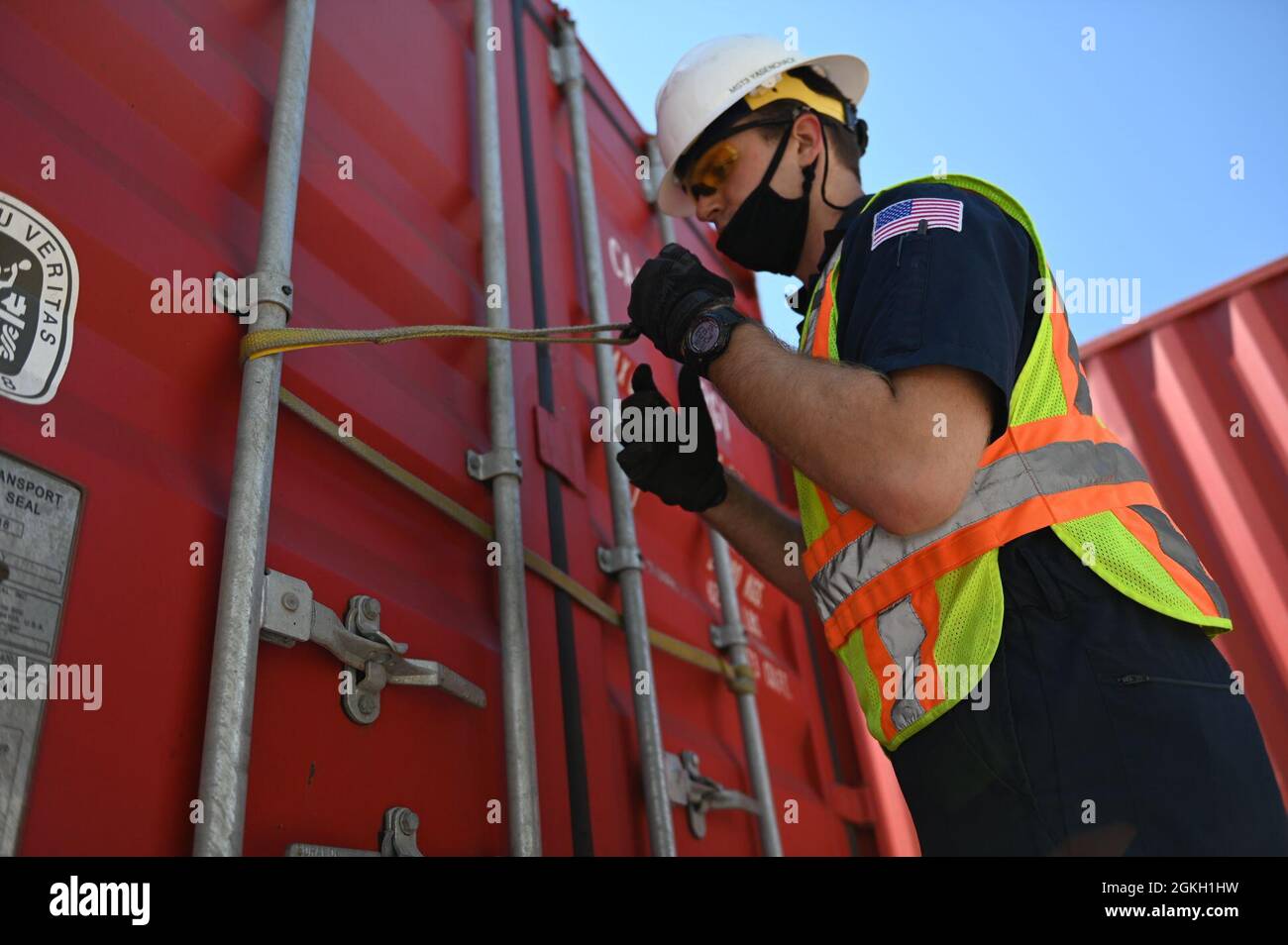 U.S. Coast Guard Petty Officer 3a classe Gabe Yasenchack, un tecnico di scienze marine presso il settore della Guardia Costiera Maryland-National Capital Region, apre un contenitore per cercare pericoli non dichiarati durante un'operazione di forza di sciopero multi-agenzia al porto di Baltimora, 20 aprile 2021. Un MASFO è condotto per garantire il trasporto sicuro e legale di carichi containerizzati. Foto Stock