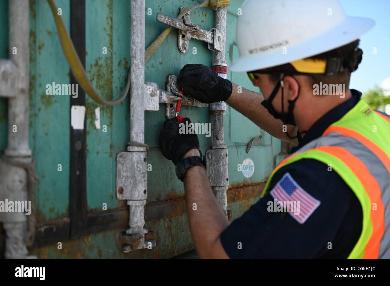 U.S. Coast Guard Petty Officer terza classe Gabe Yasenchack, un tecnico di scienze marine presso il settore della Guardia Costiera Maryland-National Capital Region, rimuove un sigillo da un contenitore per cercare pericoli non dichiarati durante un'operazione di forza di sciopero multi-agenzia al porto di Baltimora, 20 aprile 2021. Un MASFO è condotto per garantire il trasporto sicuro e legale di carichi containerizzati. Foto Stock