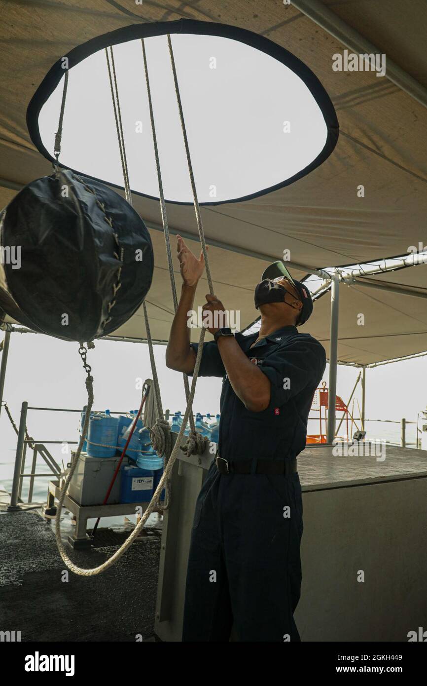 210420-A-IY623-0069 GOLFO ARABICO (20 aprile 2021) – Quartermaster III Classe Delvin Wright, assegnato alla nave per le contromisure da miniera USS Sentry (MCM 3), solleva una forma giornaliera utilizzata per segnalare lo stato di navigazione di una nave, durante l'esercizio Artemis Trident 21 nel Golfo Arabico, aprile 20. Artemis Trident 21 è un esercizio multilaterale di contromisure tra Regno Unito, Australia, Francia e Stati Uniti, progettato per migliorare l'interoperabilità reciproca e le capacità nella caccia e sdoganamento delle miniere, nella sicurezza marittima e nelle operazioni di immersione, consentendo alle forze navali partecipanti di sviluppare efficacemente il necessario Foto Stock