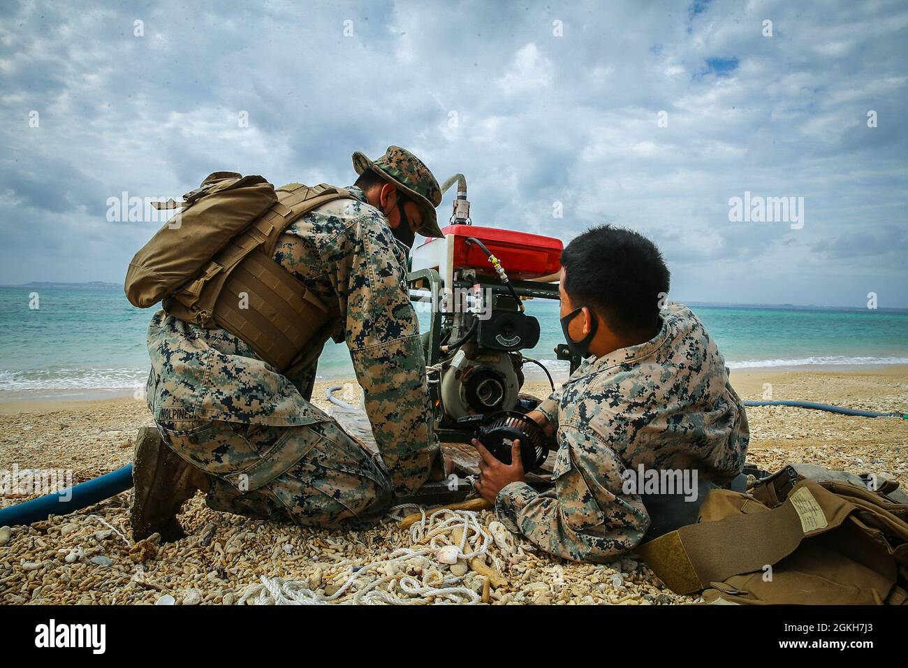 US Marine Corps Lance CPL. Hugo Gallegos, a destra, e Lance CPL. Pabel Nolpineda, entrambi i tecnici del supporto idrico con Engineer Support Company, 9th Engineer Support Battalion, 3d Marine Logistics Group, discutono di come risolvere il problema della partenza di una pompa dell'acqua grezza durante Exercise Pacific Pioneer nell'area di formazione Kin Blue, Okinawa, Giappone, 21 aprile 2021. Pacific Pioneer serve come 9th ESB's Marine Corps Combat Readiness Evaluation, nonché un'opportunità per dimostrare la capacità di stabilire e sostenere basi avanzate di spedizione con la protezione della forza sopravvissuta, pratica l'integrazione navale, e p Foto Stock