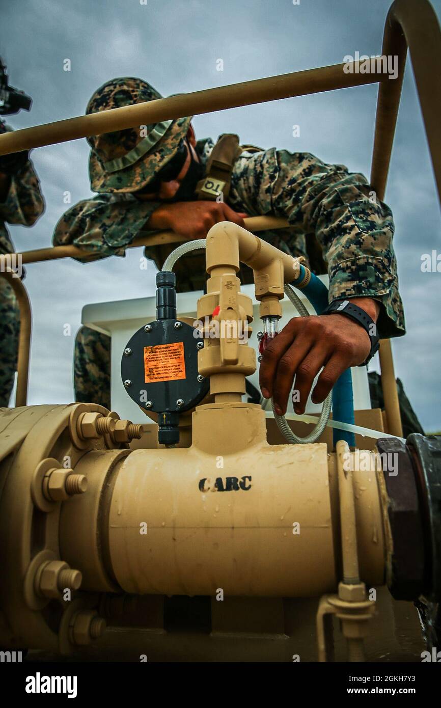 CPL del corpo marino degli Stati Uniti. Kevin Galaz, tecnico del supporto idrico con 9th Engineer Support Battalion, 3d Marine Logistics Group, monitora un'unità di ipoclorazione, facendo circolare livelli adeguati di cloro attraverso acqua marina purificata per uccidere i batteri in un serbatoio d'acqua durante l'esercizio Pacific Pioneer, Okinawa, Giappone, 21 aprile 2021. Pacific Pioneer serve come 9th ESB's Marine Corps Combat Readiness Evaluation, nonché un'opportunità per dimostrare la capacità di stabilire e sostenere basi avanzate di spedizione con protezione della forza sopravvissuta, pratica l'integrazione navale, e posizione a lungo raggio p Foto Stock