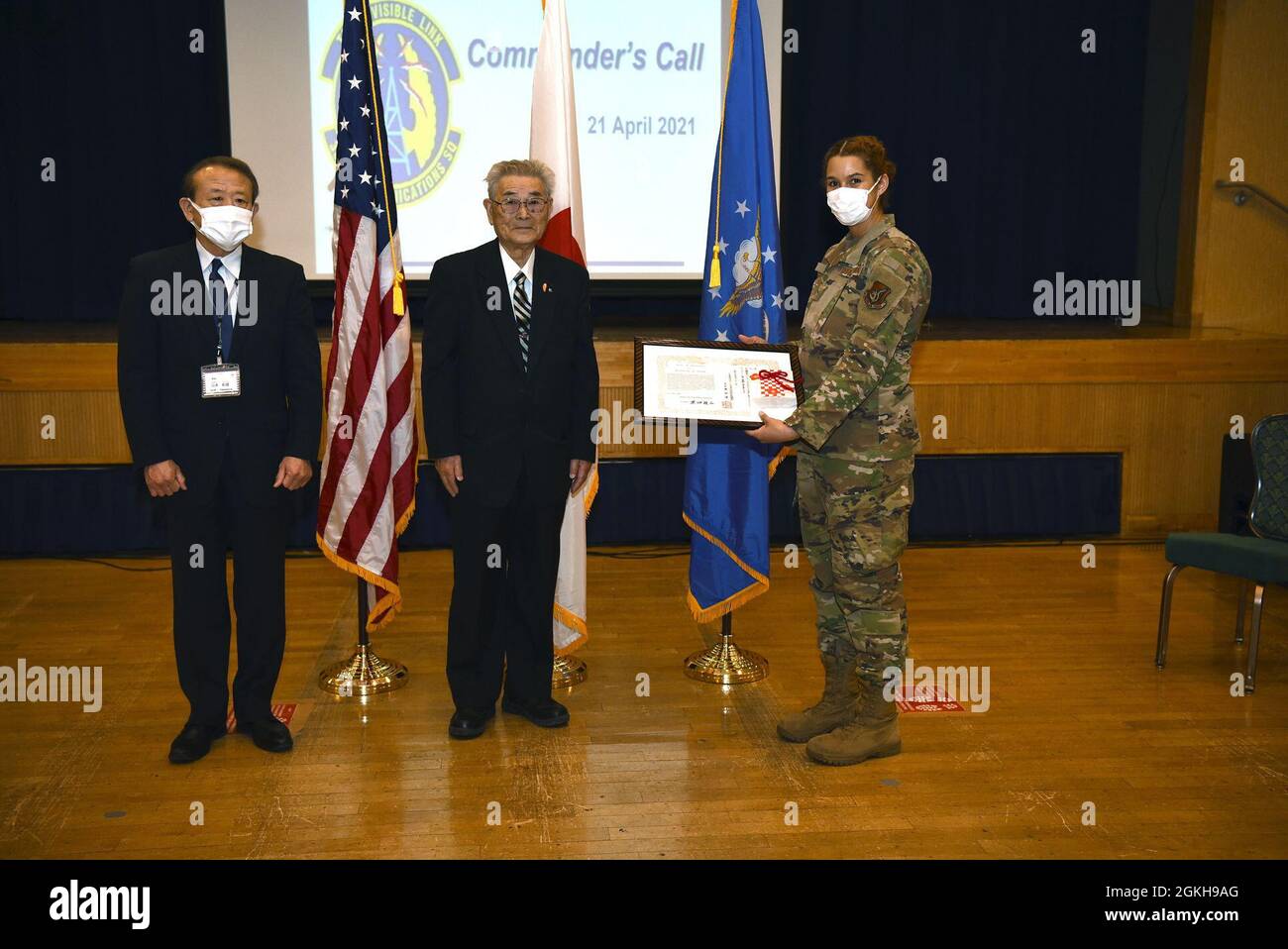 Funzionari della città di Misawa, direttore di Okamisawa “Jido-kan”, O dopo il programma scolastico, Norio Yamamamoto e il Vice Presidente del Social Welfare, Ishi Numata, presentano una lettera di apprezzamento al tecnico dei sistemi di trasmissione a radiofrequenza della US Air Force Senior Airman Hannah Tatum, 35esimo tecnico dei sistemi di trasmissione a radiofrequenza della comunicazione Squadron, durante una chiamata generale sulla base aerea Misawa, 21 aprile 2021. Tatum fa parte di Jido-kan da quando è arrivata a Misawa nel 2018. Foto Stock