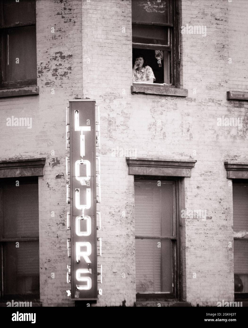 1970 LIQUORI SEGNO NEON EDIFICIO DI APPARTAMENTO ANONIMO DONNA NON IDENTIFICATA NELLA FINESTRA DI SOPRA BERE ALCOL - S19063 HAR001 HARS APPARTAMENTO B&W TRISTEZZA ALCOLICA NEON DIPENDENZA TESTA E SPALLE ALCOLISMO SCELTA ESTERNO BASSO ANGOLO POTENTE MOOD ADDICTED CONCETTUALE CONSUMARE AL PIANO SUPERIORE SVANTAGGIATO SKID ROW CITTÀ INTERNA ADDICT DELUSO DISCONNESSO ABITUDINE METÀ-ADULTO DONNA MEDIO-ADULTO MISERABILE NERO E BIANCO CAUCASICO ETNIA DIPENDENZA DISTRAUGHT HAR001 SENZA SPERANZA VECCHIO STILE Foto Stock