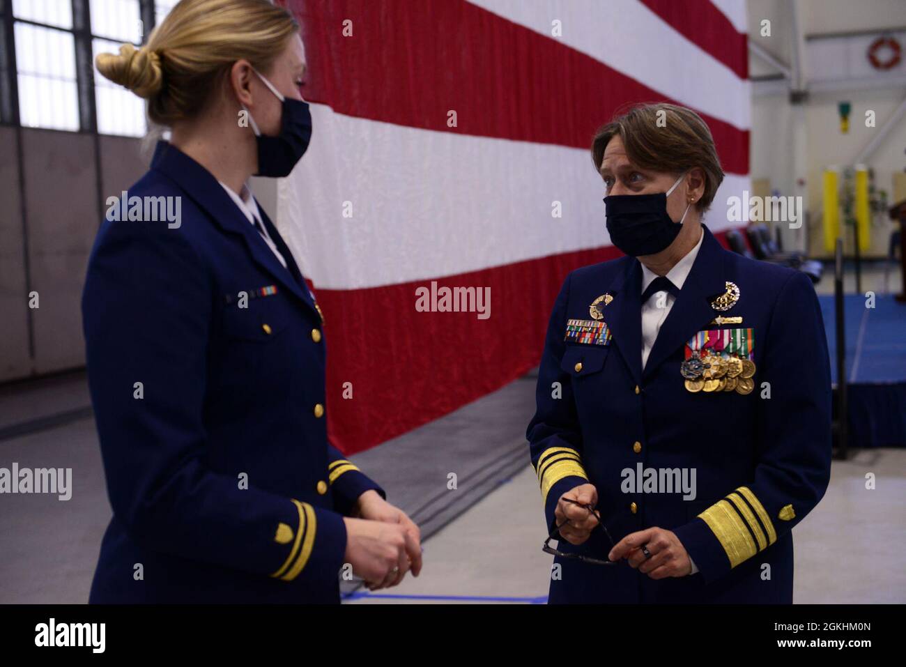 Morsa ADM. Linda Fagan, il comandante della Guardia Costiera nell'area del Pacifico, chiacchiera con il Lt. j.g. Susan West in seguito alla cerimonia di smantellamento di Douglas Munro tenutasi a Kodiak, Alaska, il 24 aprile 2021. La taglierina a base di Kodiak è l'ultima delle tagliatrici di classe di resistenza alta 378 piedi, che ha servito la Guardia Costiera conducendo missioni nazionali e internazionali per 49 anni. Foto Stock