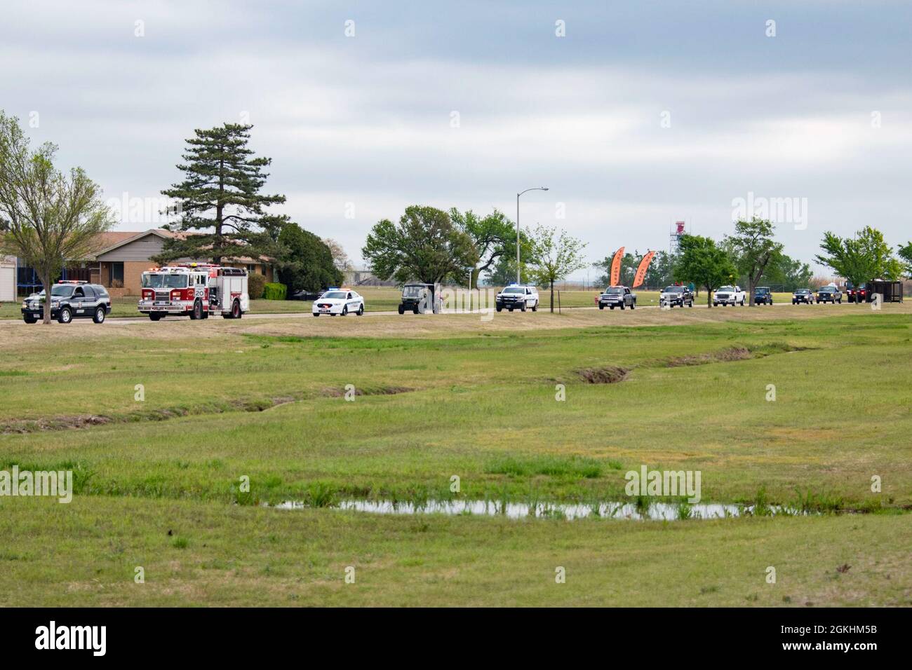 I veicoli nel mese della parata militare dei bambini si allineano per guidare intorno all'alloggiamento di base, 24 aprile 2021, alla base dell'aeronautica di Altus, Oklahoma. I partecipanti alla sfilata hanno incluso i membri del 97a Ingegnere civile, del 97a Squadrone delle forze di sicurezza, del 97a Squadrone del supporto operativo, delle 97a Agenzie del personale dell'ala e del 5ottesimo Squadrone dell'Airlift. Foto Stock