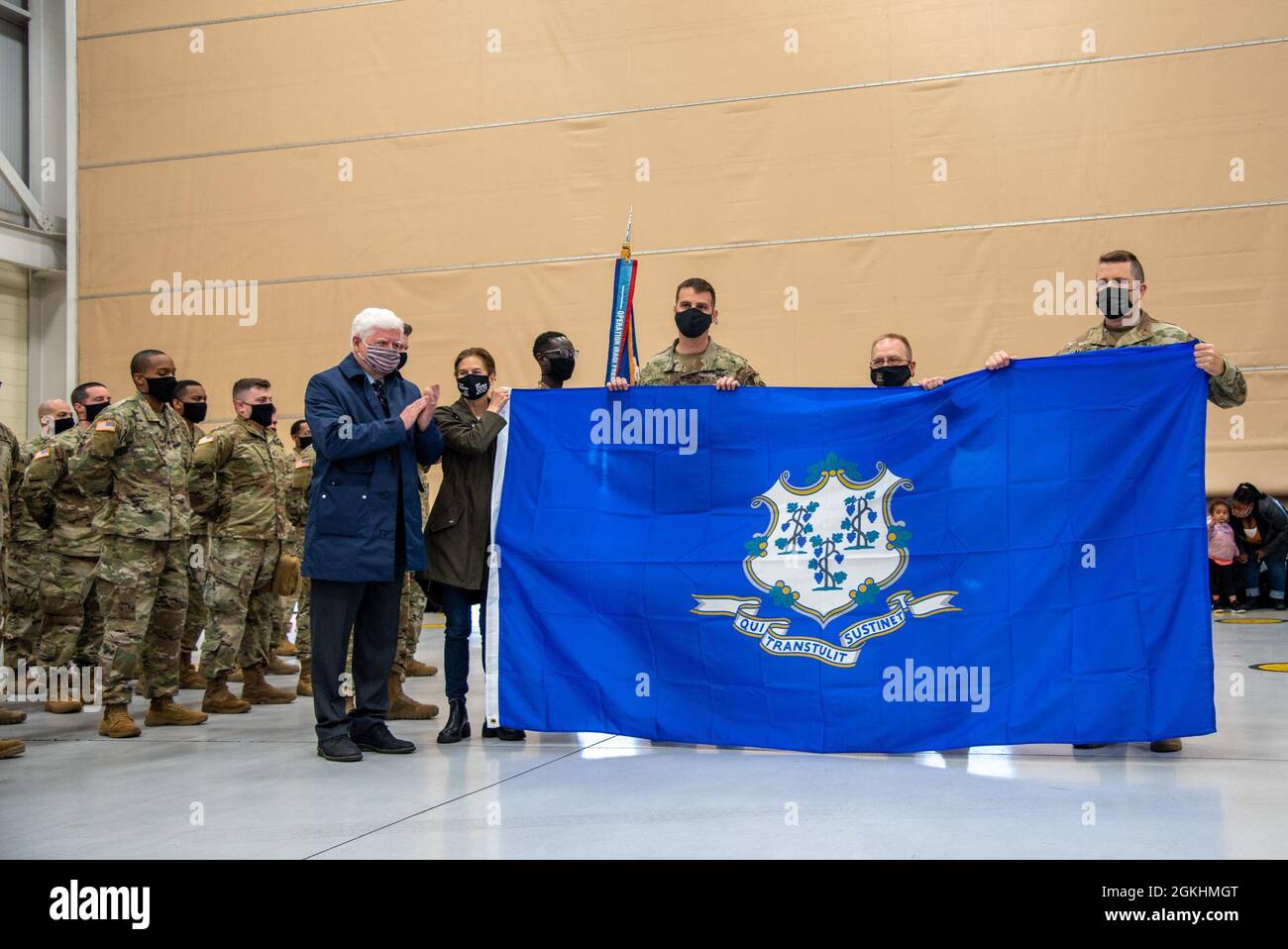 Rappresentante John Larson, Lt. Gov. Susan Bysiewicz e il Gen. Francis Evon presentano una bandiera del Connecticut a HHC 1-169th Aviation Regiment ad un evento di fine giornata il 25 aprile 2021 a Windsor Locks, Conn. L'unità partì il Connecticut quel giorno per lo spiegamento in Kosovo. Foto Stock