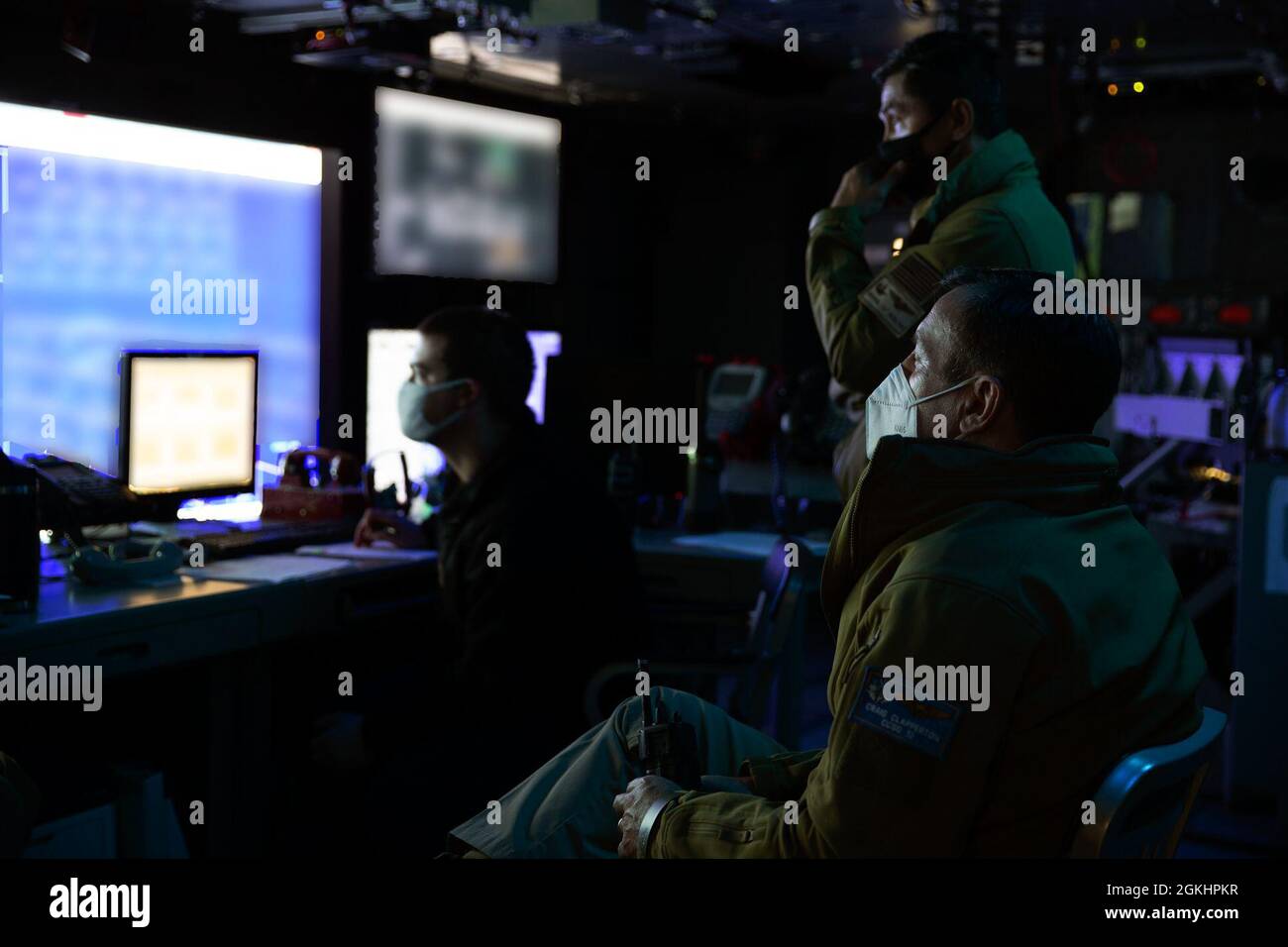 ADM posteriore. Craig Clapperton, comandante, Carrier Strike Group (CSG) 12, davanti, osserva un esercizio di difesa aerea nel Tactical Flag Command Center a bordo della USS Gerald R. Ford (CVN 78), 26 aprile 2021. Sotto la guida di CSG-12, Gerald R. Ford è in corso nell'Oceano Atlantico conducendo operazioni di gruppo di sciopero di carrier integrato con CVW-8, DESRON 2 e il loro comandante di difesa Air and Missile, comandante di USS Gettysburg (CG 64). (Questa immagine è stata alterata sfocando le schermate del computer per motivi di sicurezza). Foto Stock