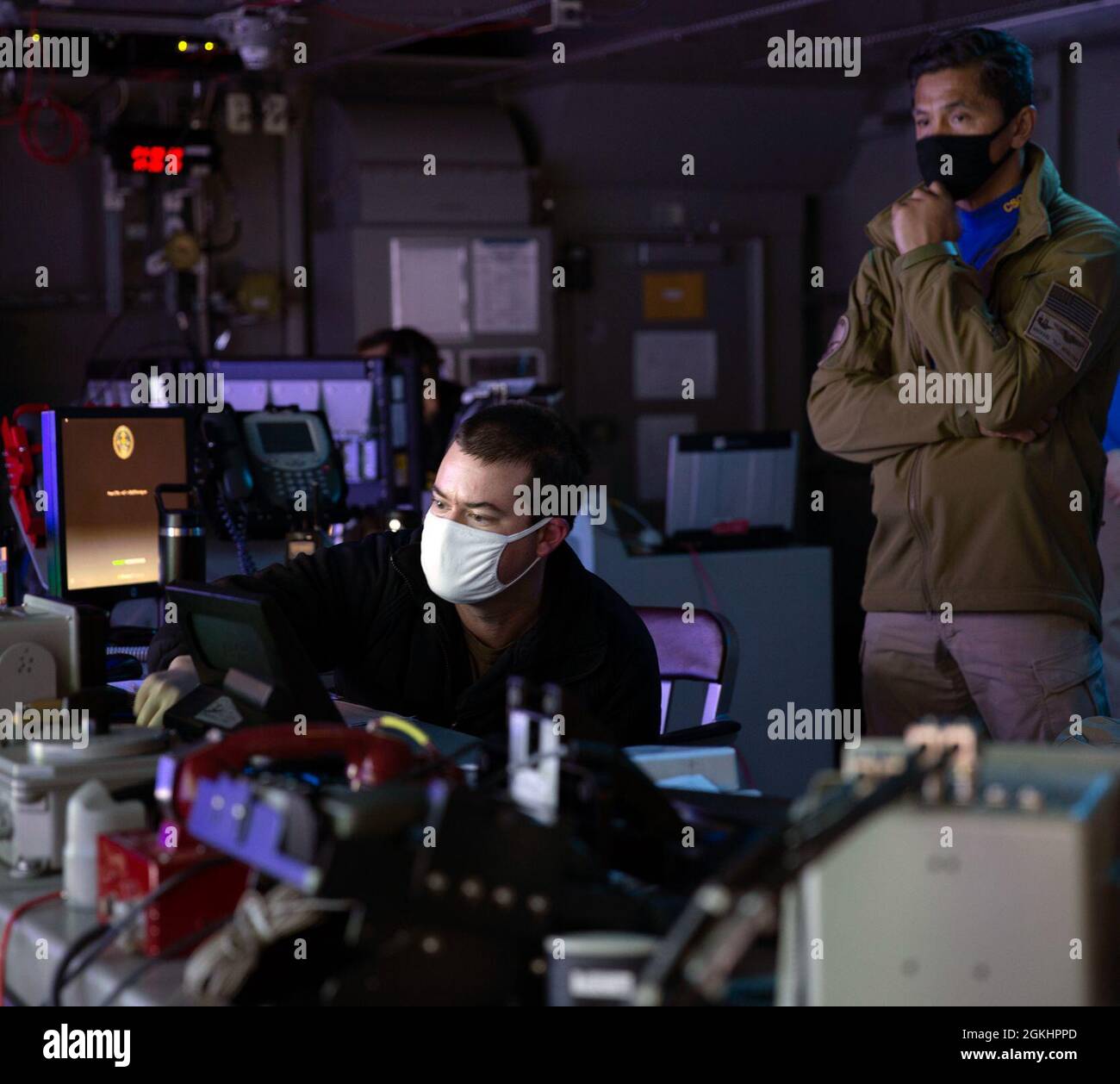 Lt. CMdR. Josh Money, left, Carrier Strike Group (CSG) 12 Strike Officer, mans una console di coordinamento per la difesa aerea e missilistica durante un esercizio di difesa aerea nel Tactical Flag Command Center a bordo di USS Gerald R. Ford (CVN 78), 26 aprile 2021. Sotto la guida di CSG-12, Gerald R. Ford è in corso nell'Oceano Atlantico conducendo operazioni di gruppo di sciopero di carrier integrato con CVW-8, DESRON 2 e il loro comandante di difesa Air and Missile, comandante di USS Gettysburg (CG 64). (Questa immagine è stata alterata sfocando le schermate del computer per motivi di sicurezza). Foto Stock