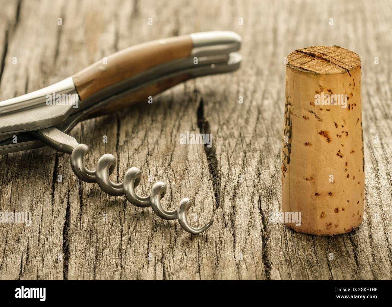 Primo piano di un sughero da vino e mandrino di un cavatappi su legno rustico Foto Stock