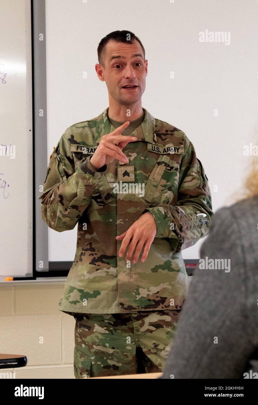 Esercito degli Stati Uniti Sgt. Bill Fitrakis, 1460th Transportation Company, Michigan Army National Guard, attualmente in servizio con COVID-19 Vaccine Testing Team Task Force Spartan, è certificato in American Sign Language, e spiega il processo di vaccinazione durante la clinica di vaccinazione tenutasi presso la Marine City Middle School di Marine City, Michigan, 27 aprile 2021. Poiché la maggior parte del linguaggio dei segni è un linguaggio visivo, non può indossare una maschera in quanto non trasmetterebbe il messaggio. Il MING è stato chiesto di contribuire ad aumentare il St. Clair County Health Department per somministrare il vaccino ai residenti che serve. Foto Stock