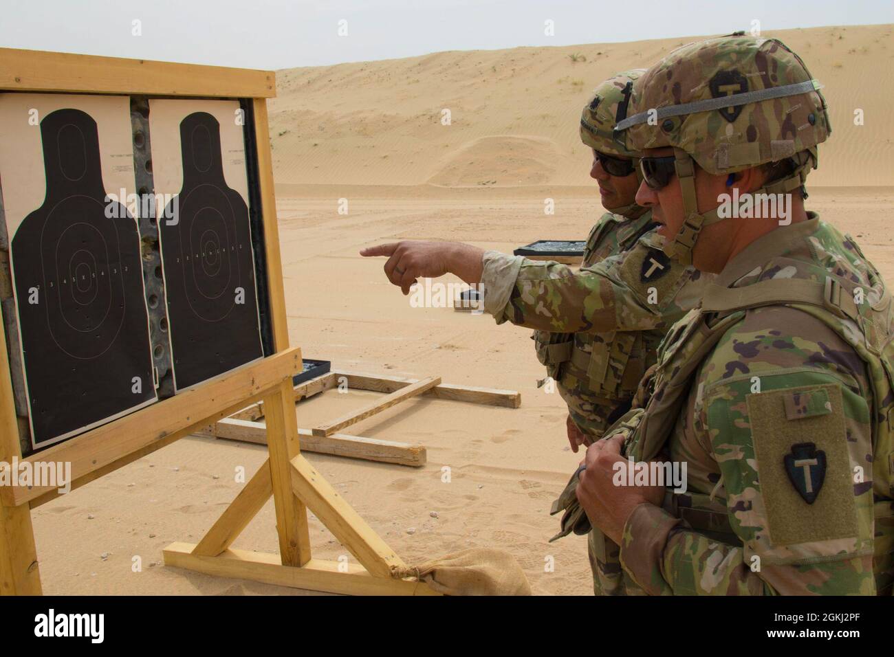 Victor Becerra, Task Force Spartan G-7 Capo delle operazioni di informazione, e staff Sgt. Aaron Moreno, con il G-32 AMR Operations non commissionato ufficiale, TF Spartan, analizza il gruppo di riprese di Moreno sul suo obiettivo cartaceo durante la parte di pistola del TF Spartan 2nd Annual Small Arms Marksmanship Competition, 28 aprile 2021, presso il complesso Udairi Range in Kuwait. I soldati dell'esercito degli Stati Uniti da TF Hellhound, TF Avalanche, 130th Field Artillery Brigade, 111th Engineer Brigade e TF Spartan hanno partecipato alla competizione di due giorni, che si è svolta per identificare i migliori marksmen di ogni TF Foto Stock