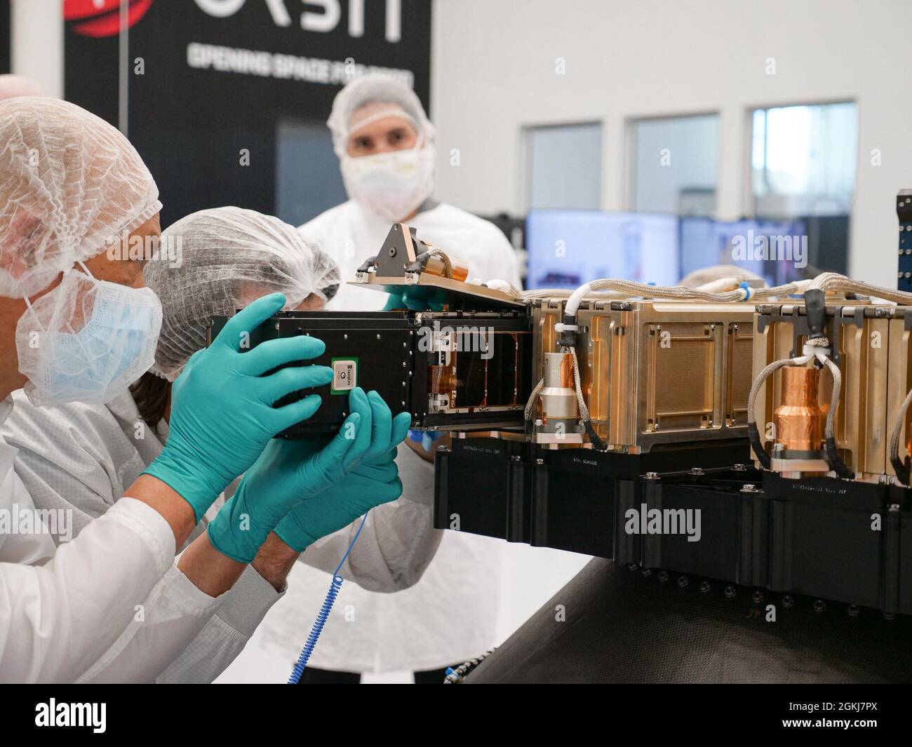 I membri del team del programma Gunsmoke piazzano un Gunsmoke-J, un comando di difesa spaziale e missilistica degli Stati Uniti e un satellite dimostrativo sulla tecnologia della capacità congiunta del team di navigazione e tempistica/Space Cross Functional, a bordo di un veicolo di lancio prima del lancio aereo del 30 giugno dal deserto di Mojave in California. Foto Stock