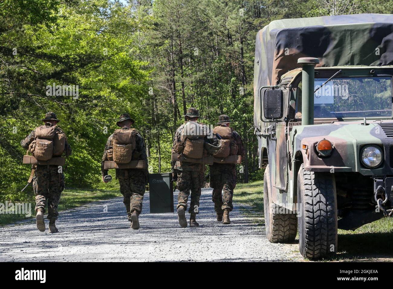 I Marines degli Stati Uniti con la scuola di base conducono un'esecuzione di rifornimento di munizioni mentre competono nel 2021 Iron Mike Competition sulla base del corpo marino Quantico, Virginia, 1 maggio 2021. I concorrenti hanno percorso una distanza di oltre 15 miglia nel corso di 11 ore, completando diverse sfide di abilità fisiche e fondamentali lungo il percorso. Foto Stock