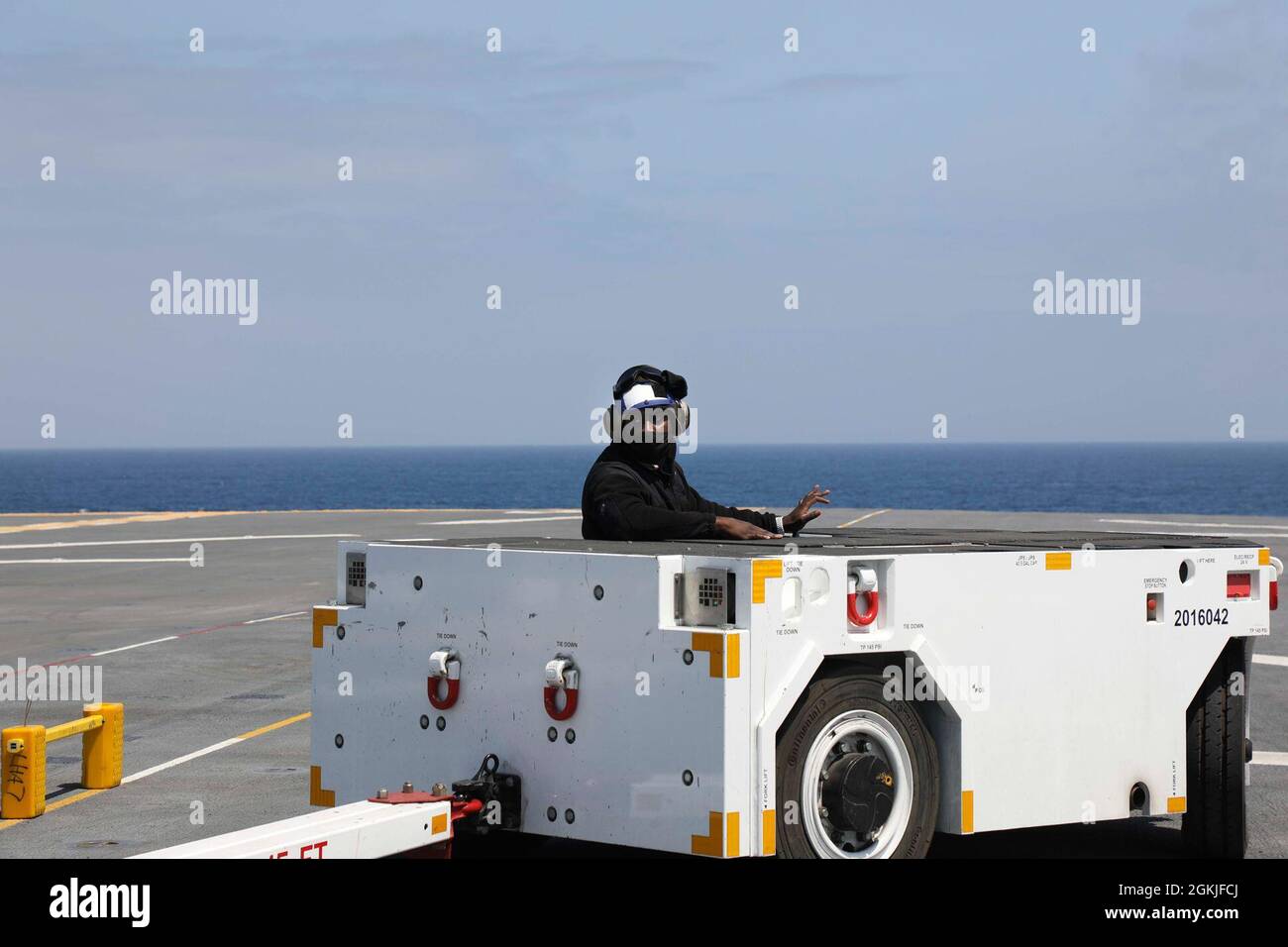 210502-N-OP825-1058 OCEANO PACIFICO (2 maggio 2021) – Aviation Boatswain’s Mate (Handling) Airman Nevin Harris, dalla California, MD., pratica manovre del camion di traino sul ponte di volo a bordo della nave d’assalto anfibio USS Tripoli (LHA 7), 2 maggio. Tripoli sta conducendo operazioni di routine nella terza flotta statunitense. Foto Stock