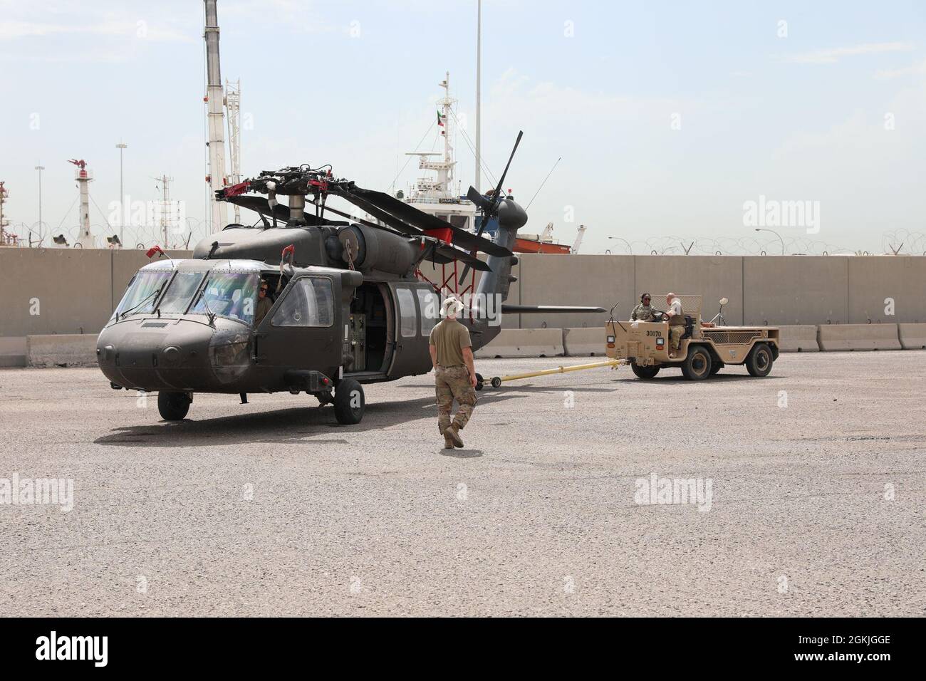 Soldati assegnati al 1100esimo Theater Aviation Sustment Maintenance Group e Bravo Company, 628esimo Aviation Support Battaglione spostare un elicottero UH-60 Black Hawk dopo aver ripiegato la pala rotante principale in preparazione al ridispiegamento al porto di Shuaiba, Kuwait, 2 maggio 2021. Gli elicotteri appartengono alla 28a brigata dell'aviazione da combattimento di Expeditionary, un'unità della Guardia Nazionale basata su Fort Indiantown Gap, Pennsylvania. Foto Stock