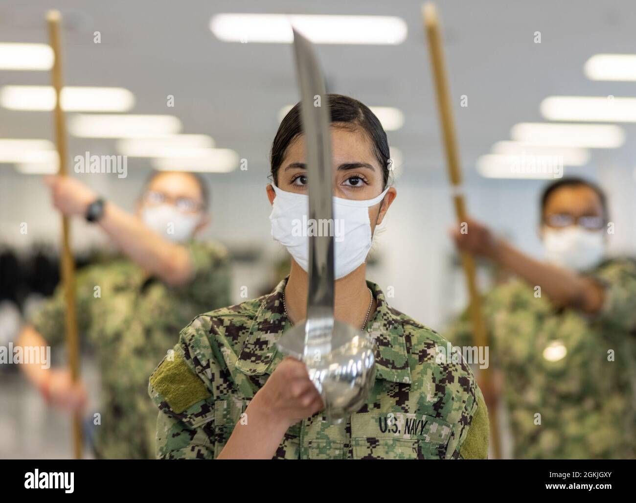 Yara Lizbeth Suarez, un ufficiale di reclutamento, presenta le armi durante la pratica di perforazione all'interno di un compartimento delle caserme di reclutamento USS Enterprise al comando di addestramento di reclutamento. Più di 40,000 reclute si allenano ogni anno presso l’unico campo di stivali della Marina. Foto Stock