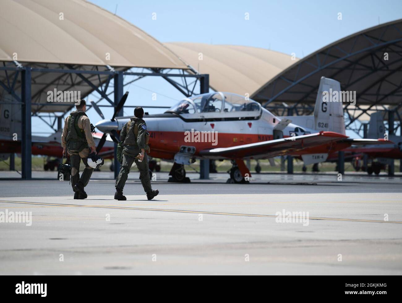 CORPUS CHRISTI, Texas (5 maggio 2021) Un aviatore navale studente e un pilota istruttore camminano fuori alla linea di volo dell'ala 4 dell'aria di addestramento a bordo della stazione aerea navale di Corpus Christi, 5 maggio 2021. TRAWING 4 comprende due squadroni di addestramento di volo primario e due squadroni intermedi/avanzati multi-motore che addestrano i piloti per la Marina, il corpo Marino, la Guardia Costiera e determinati partner militari internazionali. Foto Stock