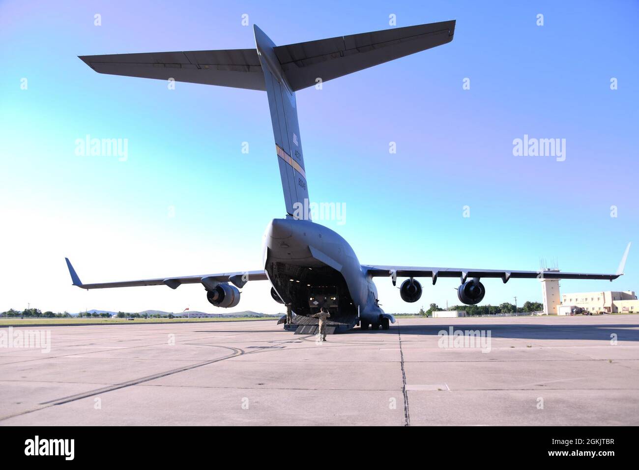 U.S. Air Force staff Sgt. Randall Moss, 58° istruttore di carico Airlift Squadron, dirige un conducente di un grande veicolo da un C-17 Globemaster III a Fort Sill, Oklahoma, 6 maggio 2021. Due C-17 sbarcarono a Fort Sill come parte di un esercizio congiunto, insegnando ai soldati a caricare il carico su un aereo. Foto Stock