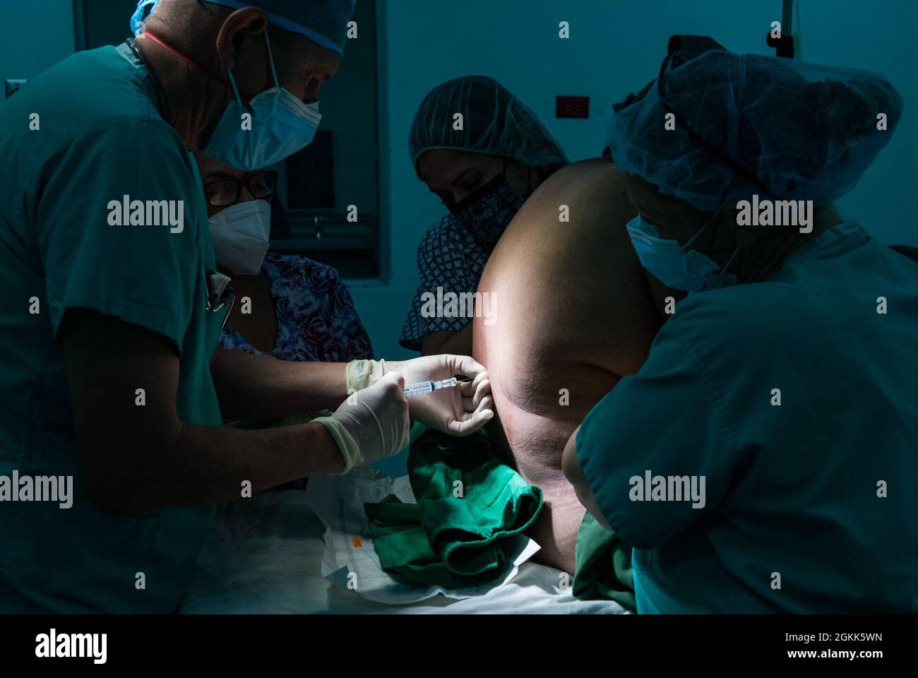 William Kogl, un anestesista infermiera con la Sezione chirurgica in avanti presso l'elemento medico, Joint Task Force-Bravo, Soto Cano Air base, Honduras, inietta un anestetico spinale prima della rimozione della cistifellea durante un esercizio di preparazione chirurgica per Resolute Sentinel 2021 a la Unión, El Salvador, maggio 12, 2021. Circa 65 membri del servizio si sono dispiegati in El Salvador per fornire una formazione congiunta e una migliore preparazione degli ingegneri civili JTF-B, dei professionisti medici e del personale di supporto attraverso attività di assistenza umanitaria. Foto Stock
