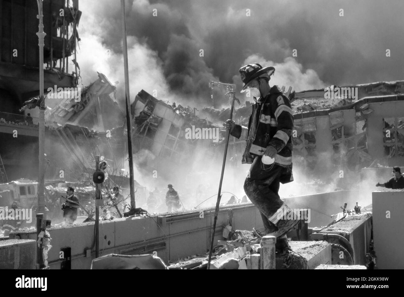 FDNY vigile del fuoco tra le macerie come le Twin Towers bruciano durante l'attacco terroristico a New York City il 11 settembre 2001. (USA) Foto Stock