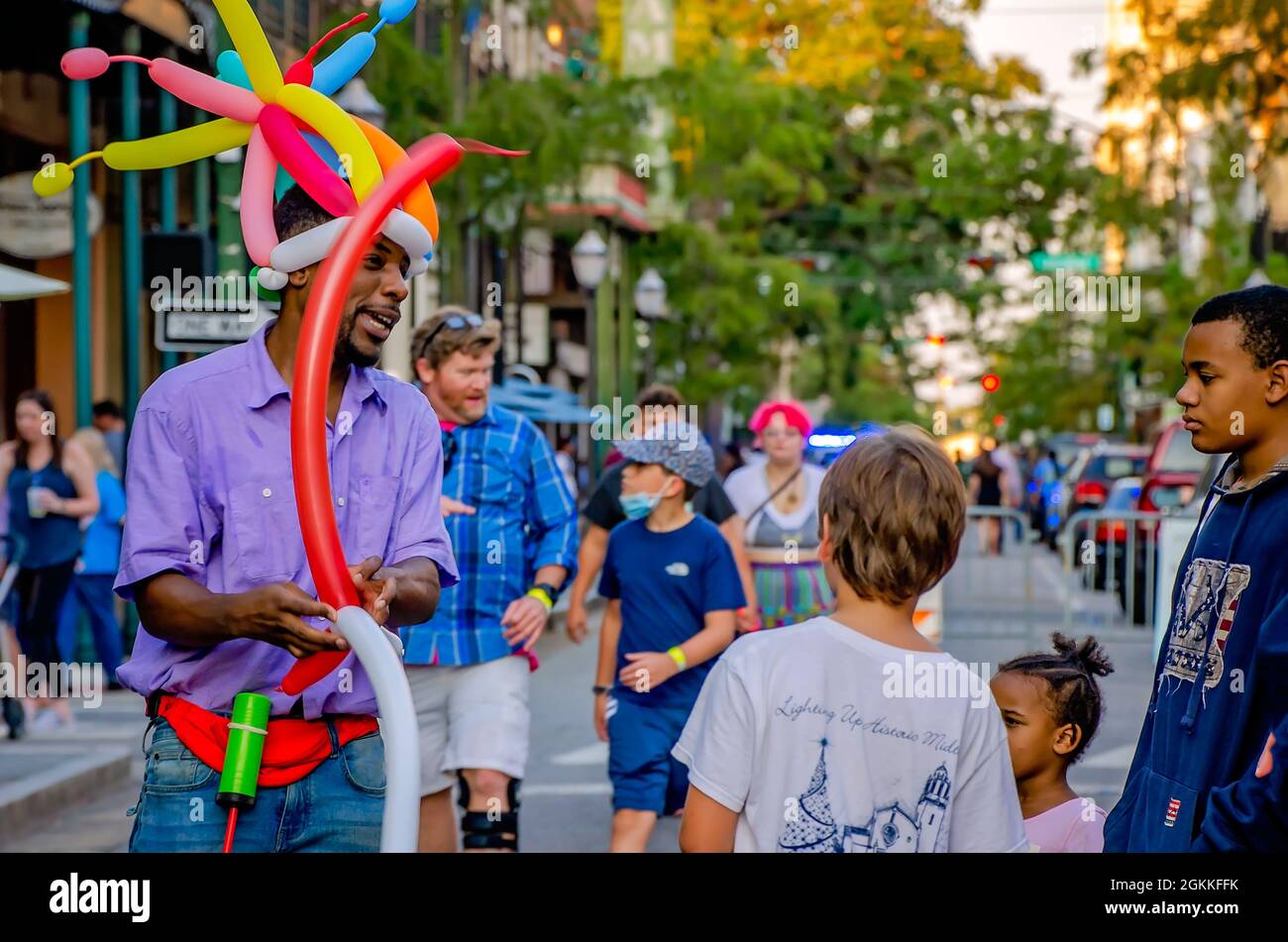 Un uomo fa gli animali della mongolfiera per i bambini su Dauphin Street durante la seconda passeggiata dell'arte del venerdì, 10 settembre 2021, in Mobile, Alabama. Foto Stock