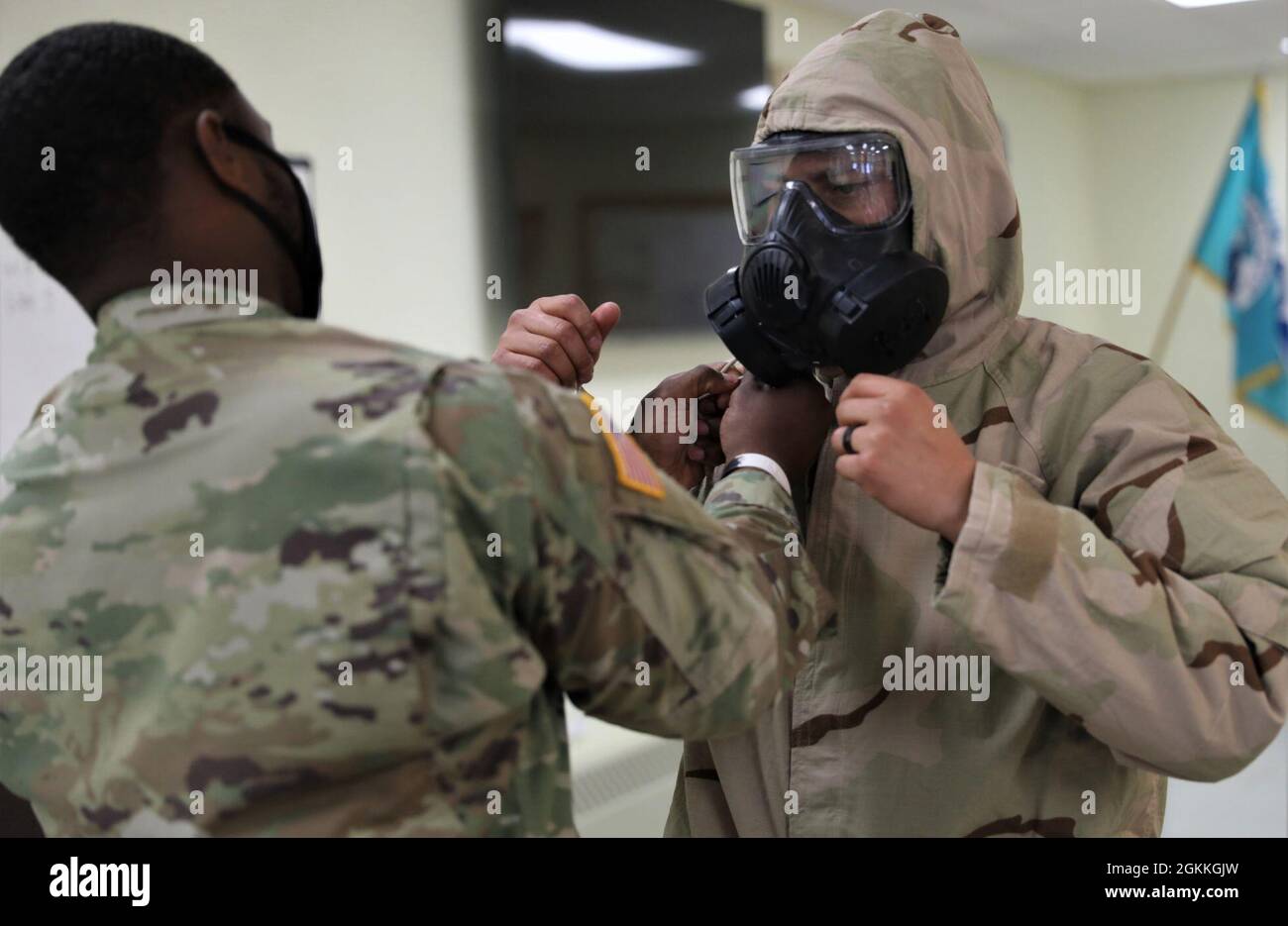 Un membro del cadre regola la maschera pro di un competitore del guerriero migliore maggio 17 al centro di addestramento di guerra del nord nel luogo di addestramento delle rapide nere, Alaska. Foto Stock