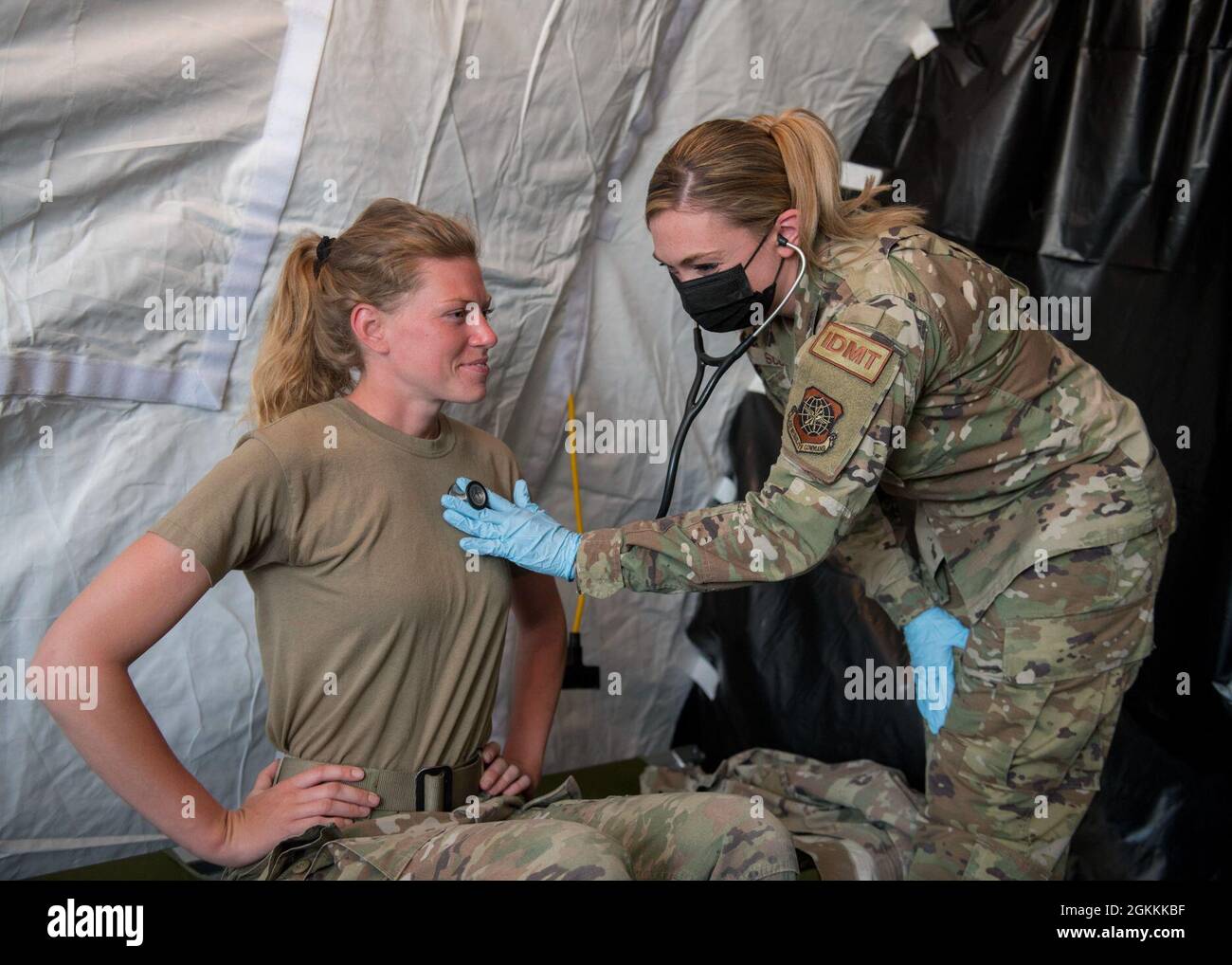 U.S. Air Force Tech. SGT. Kimberley Scofield, 6° tecnico medico indipendente pronto all'uso, ascolta i ritmi cardiaci di un partecipante all'esercizio durante l'esercizio fisico Mobility Guardian all'aeroporto di Oscoda-Wurtsmith, Oscoda, Michigan, 18 maggio 2021. Le attività dislocate in sei località del Midwest superiore e dei grandi Laghi simulano un ambiente operativo geograficamente diverso, intensificando la disponibilità di Mobility Airmen a sostenere una deterrenza strategica. Foto Stock