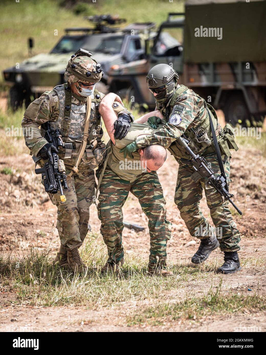 SPC. Benjamin Belcher, soldato della Alabama National Guard Bravo Company, 1-167th Battaglione, E 1 ° Lt. Choursoglou Panagiotis della 71 ° brigata Airmobile, 601 Battaglione Airmobile, abbattere un attore unnamed gioco durante un esercizio punto di controllo di entrata (ECP) come parte di DEFENDER-Europe 21, vicino Xanthi, Grecia, 18 maggio 2021. Questa formazione intensa ha permesso ad entrambi i gruppi di imparare l'uno dall'altro e di sperimentare alcune delle situazioni che potrebbero potenzialmente verificarsi. Foto Stock